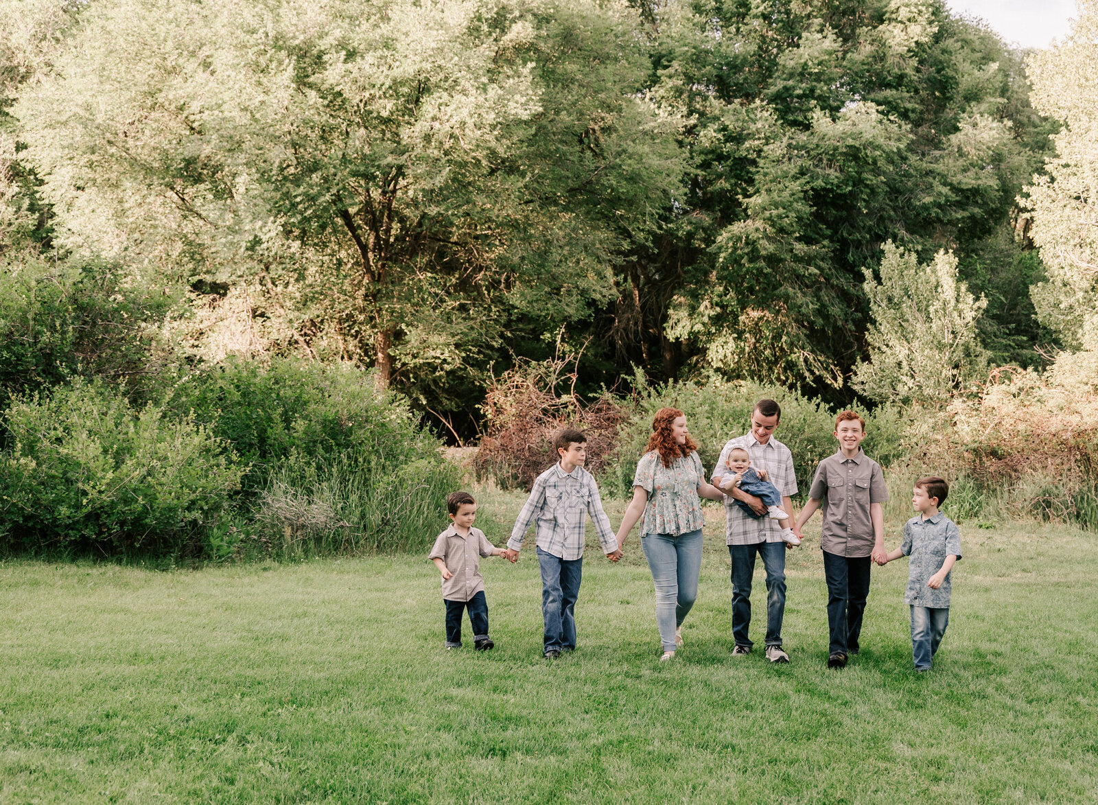 A large family of kids walk holding hands and interacting. American fork utah.