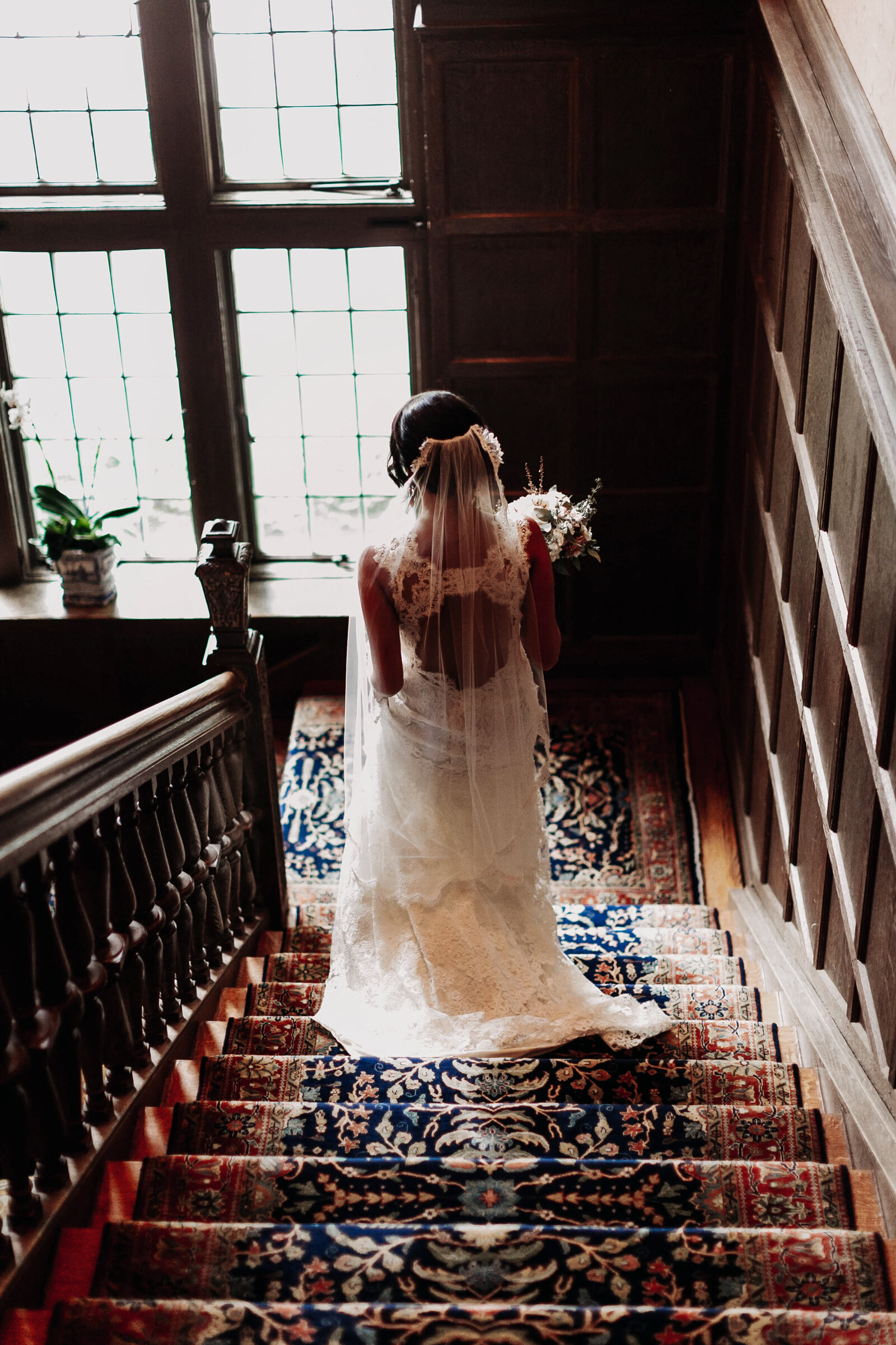back of bride in lace dress in estate mansion