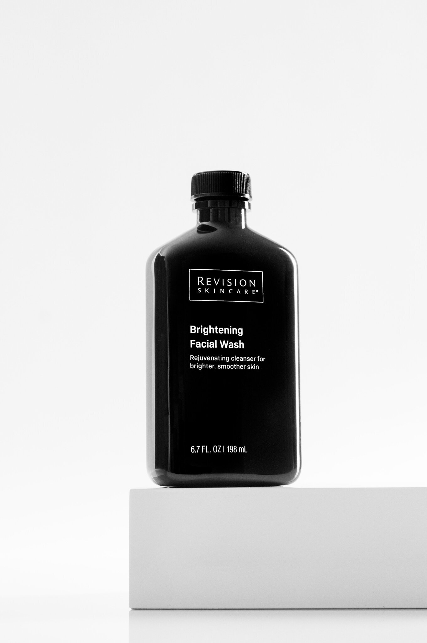 Black and white hero image of Revision Skincare Brightening Facial Wash on a white block