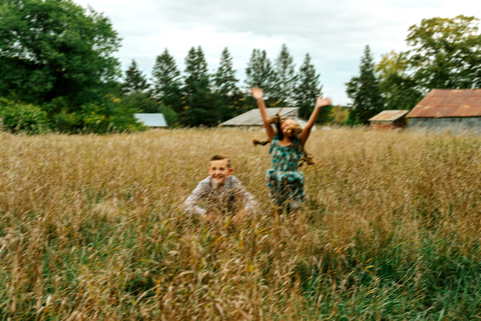 two kids jumping in field