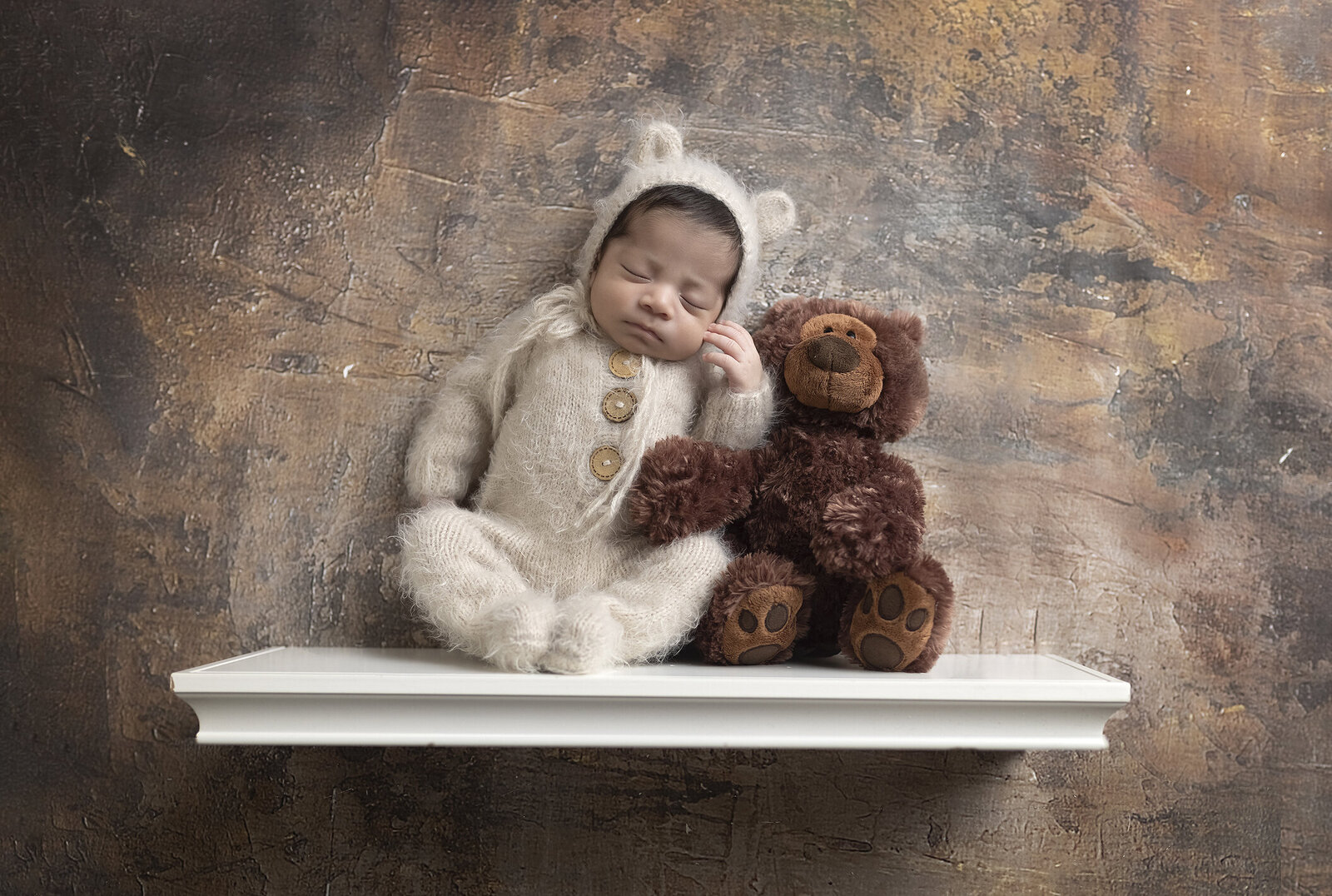 Newborn boy as teddy bear ona. shelf