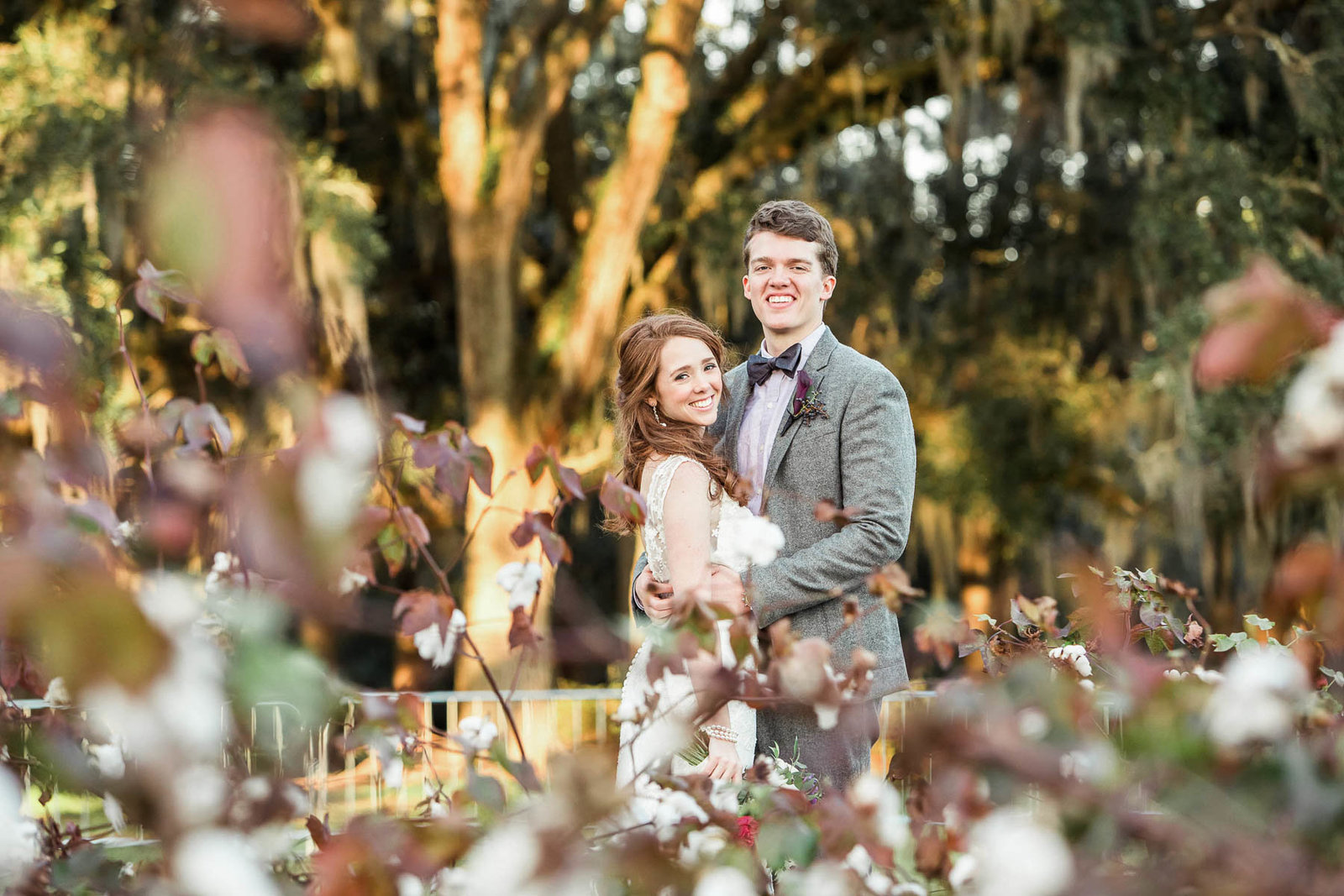 Bride and groom stand in cotton field, Boone Hall Plantation, Charleston, South Carolina
