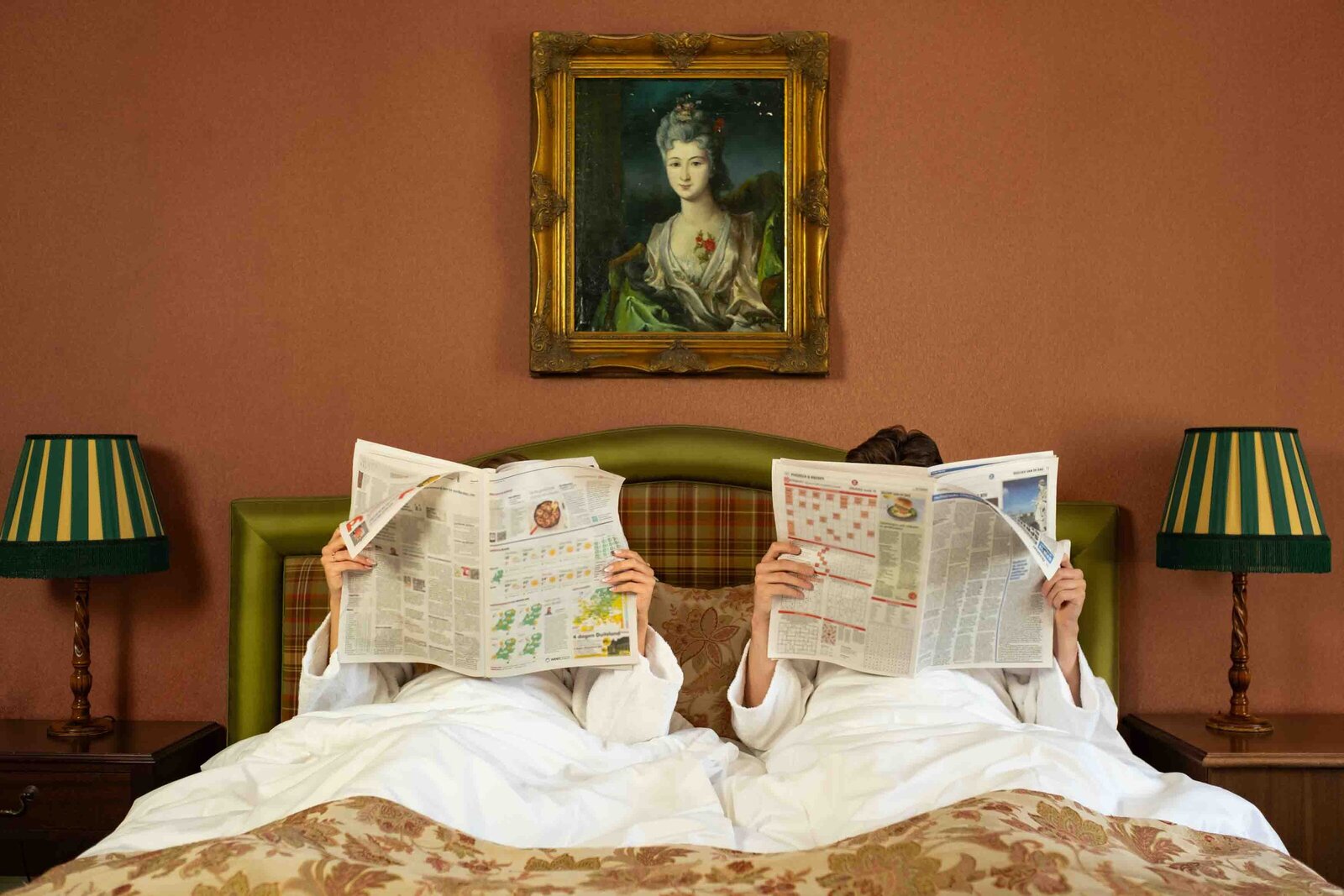 koppel leest klant in sfeervol warme hotelkamer in amsterdam uitkijkend op het landgoed