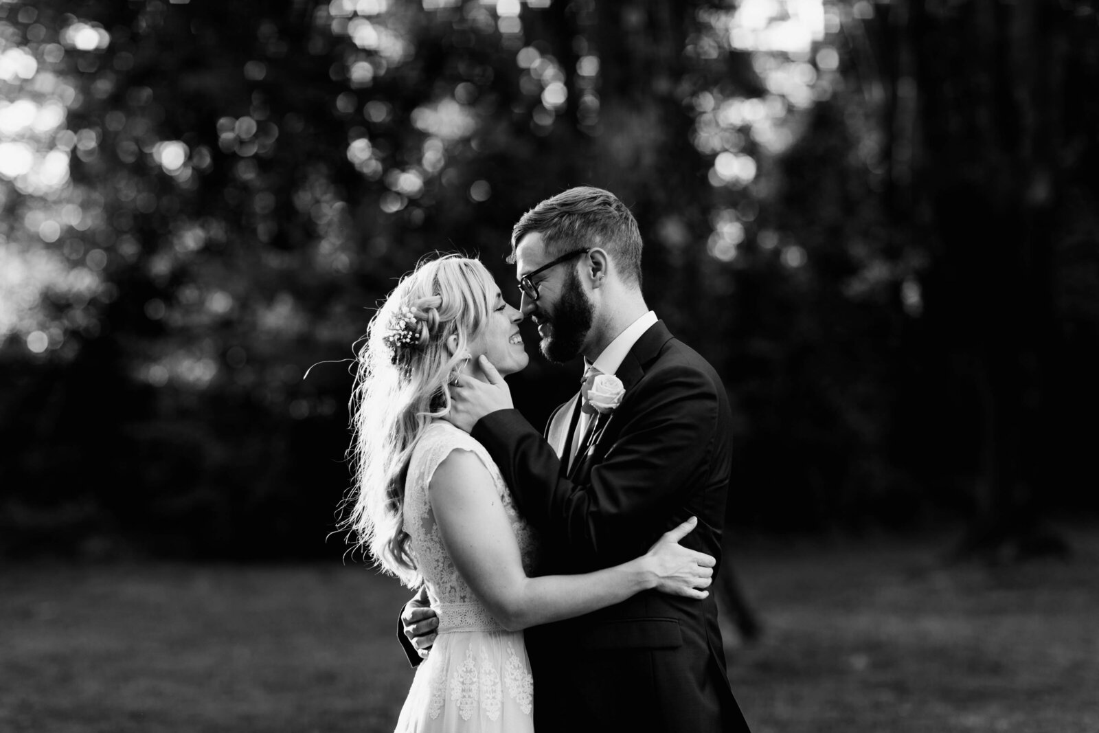 black and white bride groom kissing sunset
