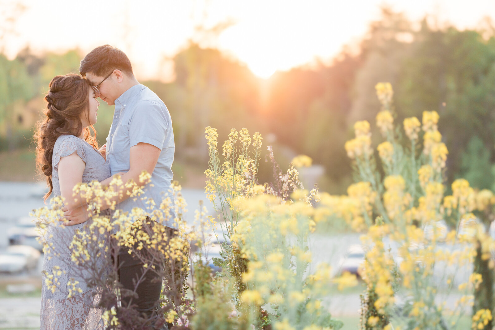 Couple looking at each other in front of the sunset with flowers