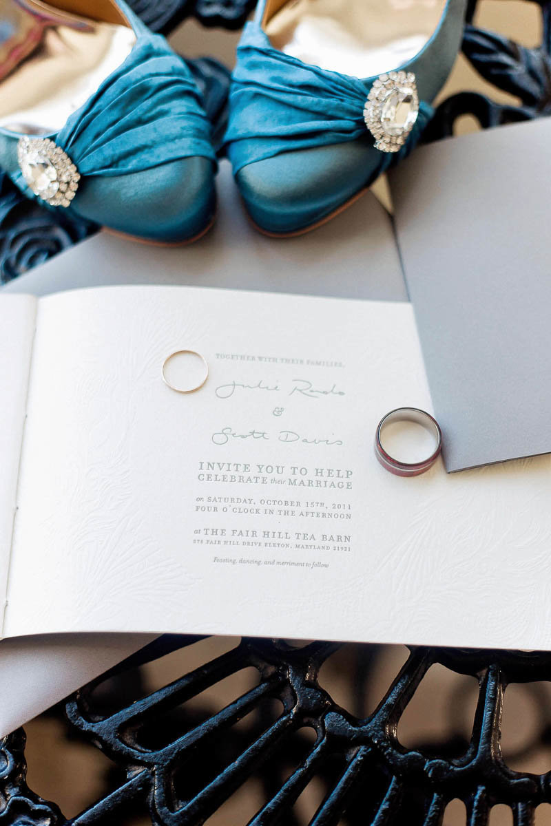 Letterpress Invitation suite is surrounded by wedding bands and blue shoes, Fair Hill Tea Barn, Elkton, Maryland. Kate Timbers Photography.