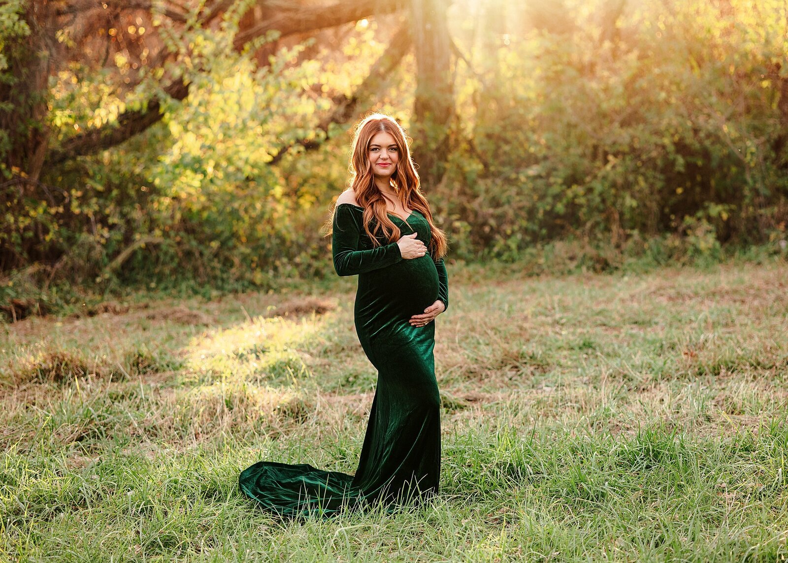 Pregnant mom cradling her belly at sunset in scott county park