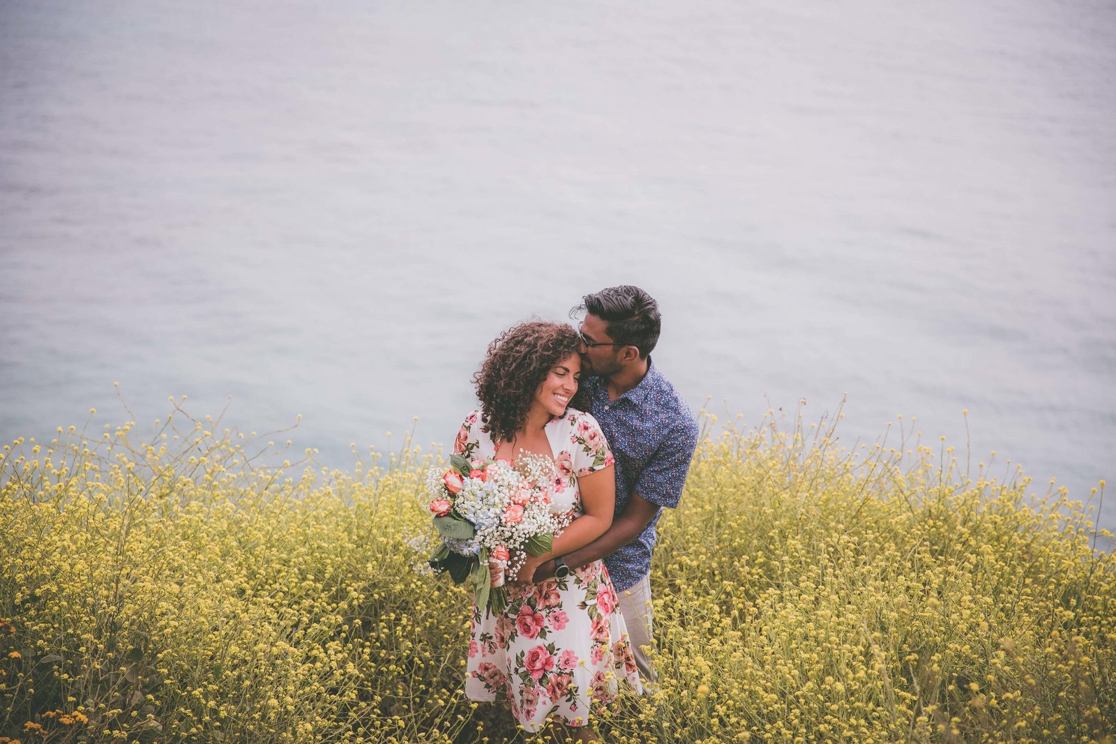 Couple goes in prom pose among yellow wildflowers in Big Sur.