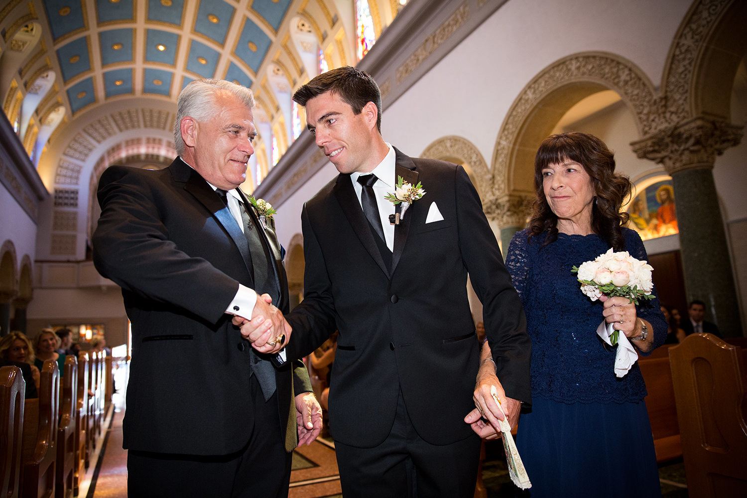 groom with his parents at ceremony