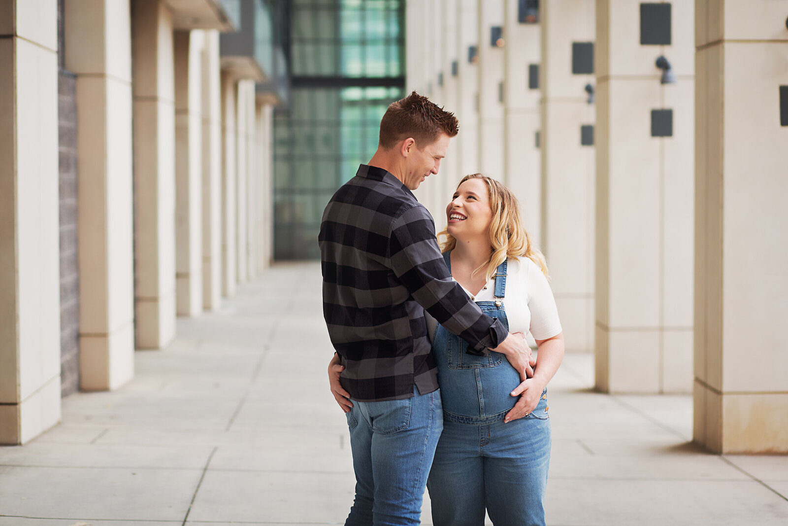 casual maternity session overalls couple looking in eyes charlotte convention center