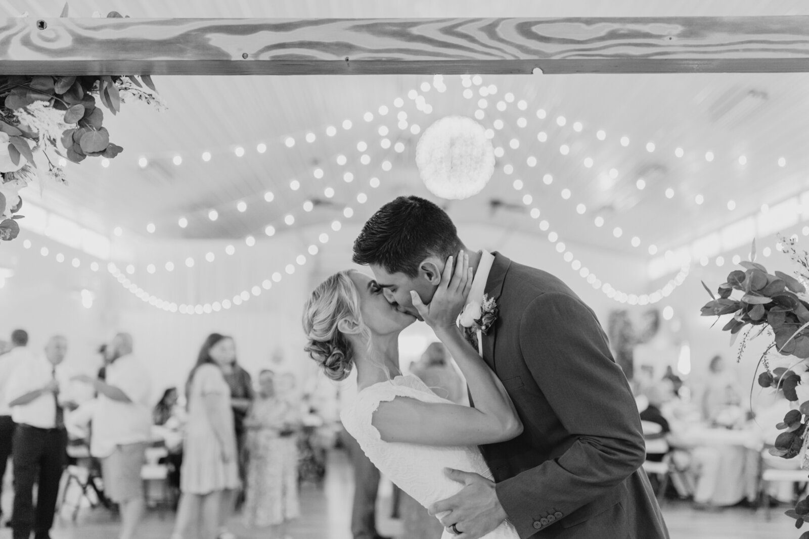 couple kisses under the alter at their wedding reception at eagles landing venue in smithfield, utah