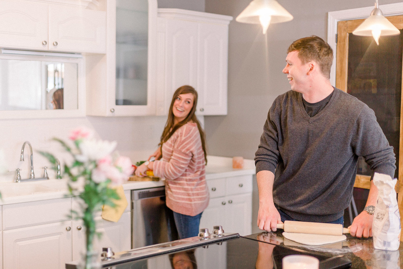 Couple laughing together as they cook dinner captured by Staci Addison Photography