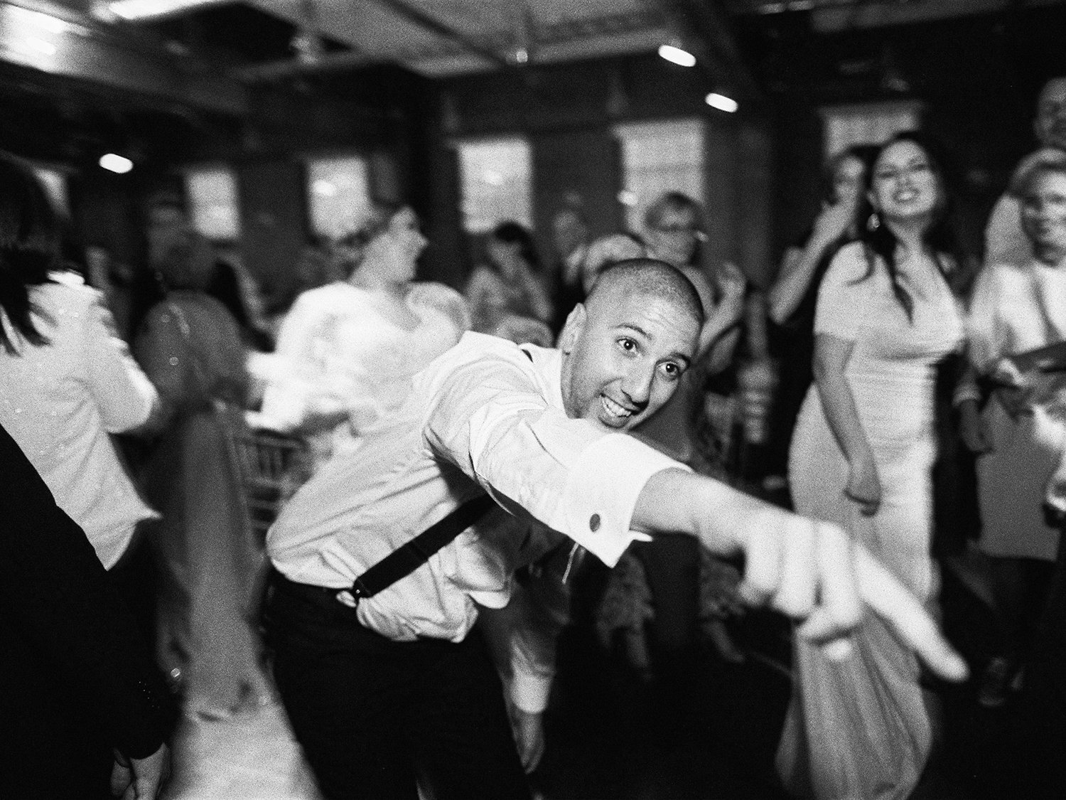 Groom dancing at his big Greek Wedding shot on black and white film