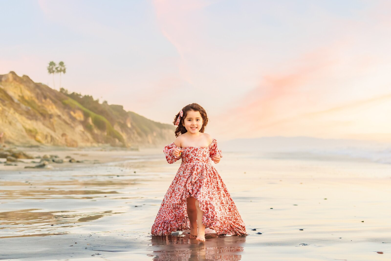 Girl wearing gown running on beach in Del Mar California