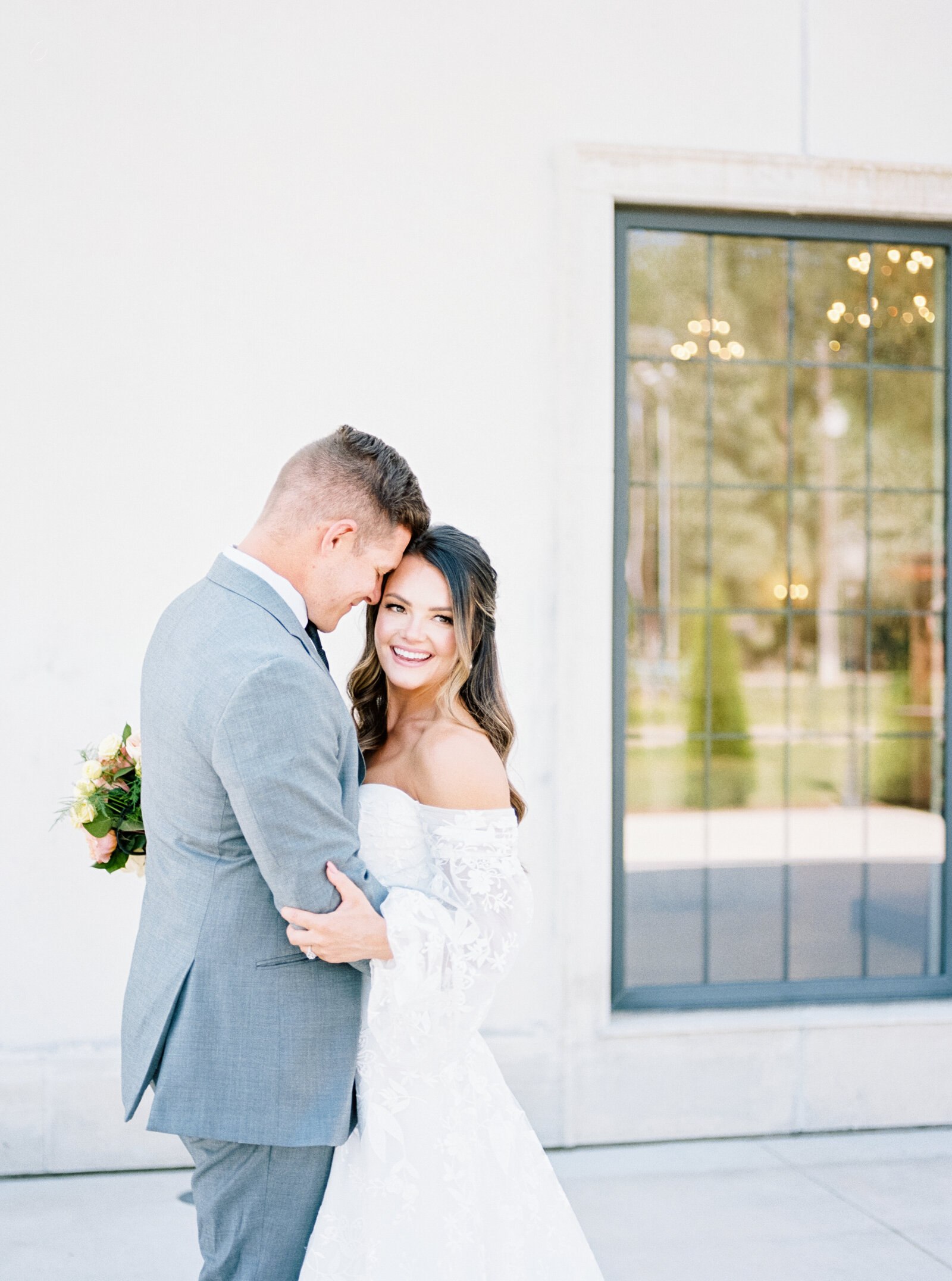 Chateau Des Fleurs Wedding Couples portraits with bride and groom next to white stucco building