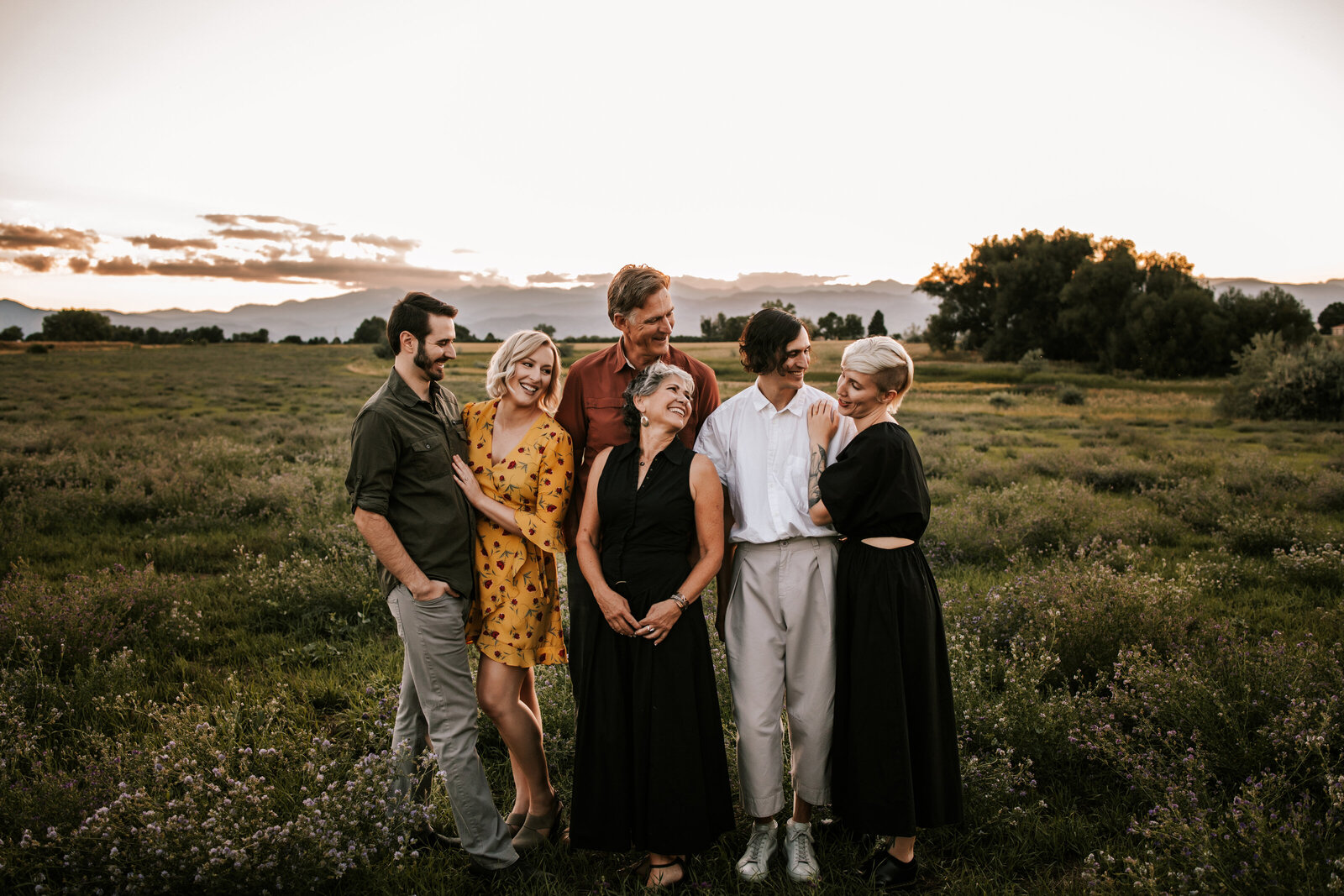 family of six adults posing for family photos in a grassy field