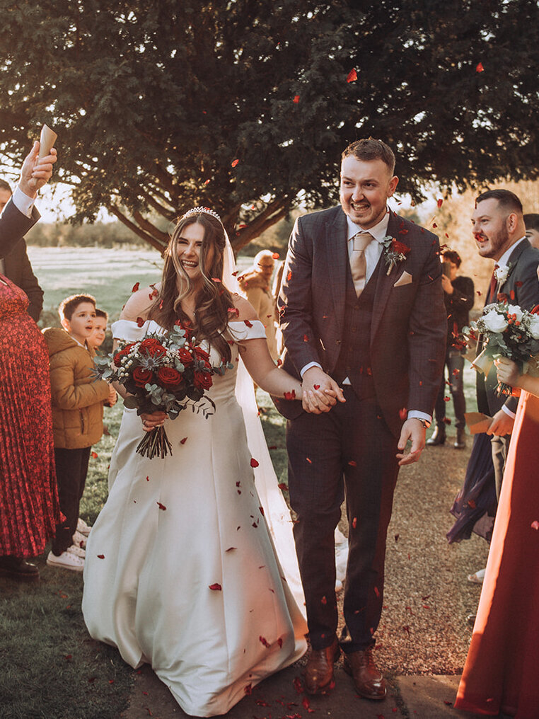 Bride and groom walking through confetti at their luxury Kent wedding