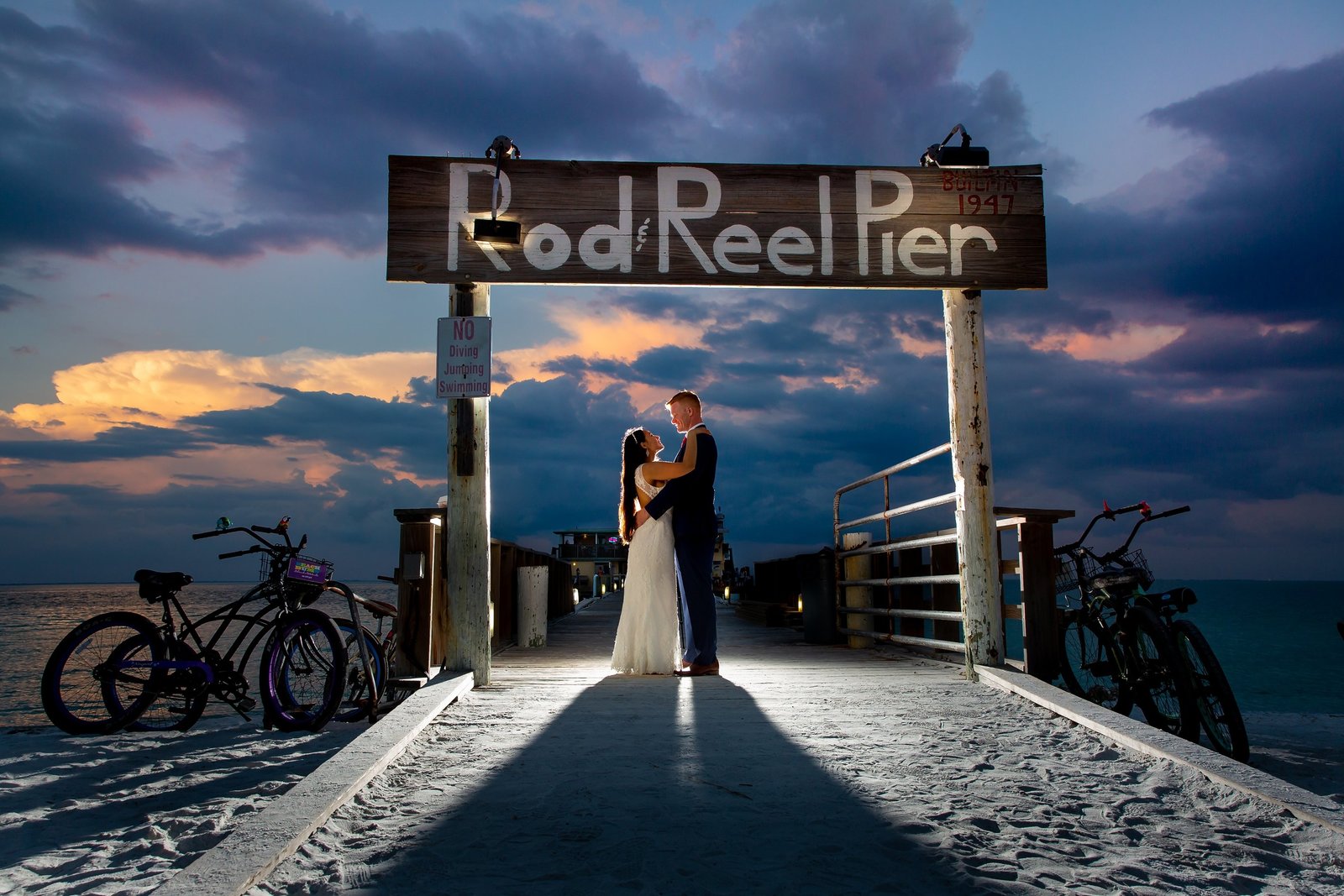 Bride and groom backlit after sunset on Rod and Reel Pier in Anna Maria, Fl