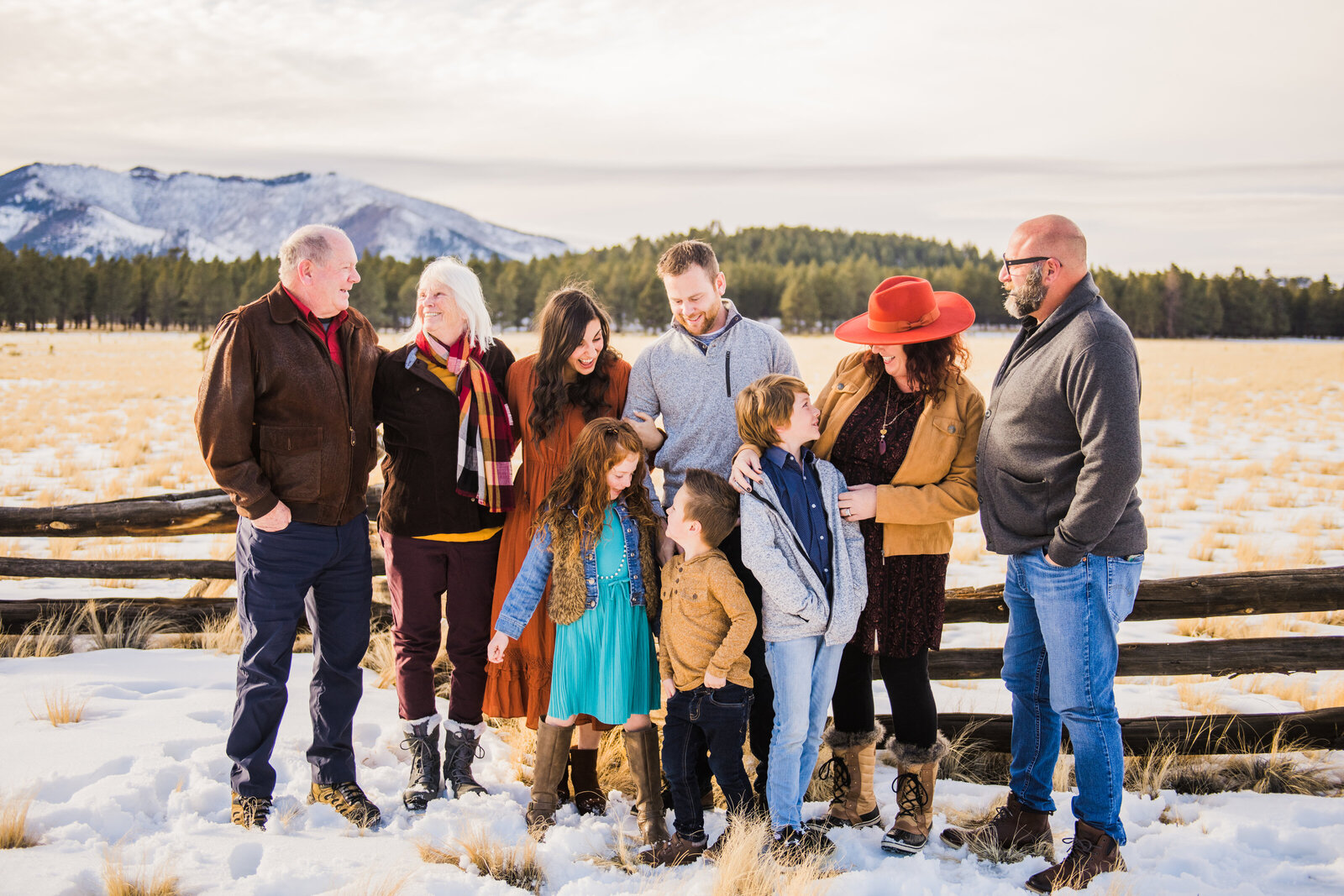 Flagstaff family in snow looking at each other Kendrick Park mountains behind