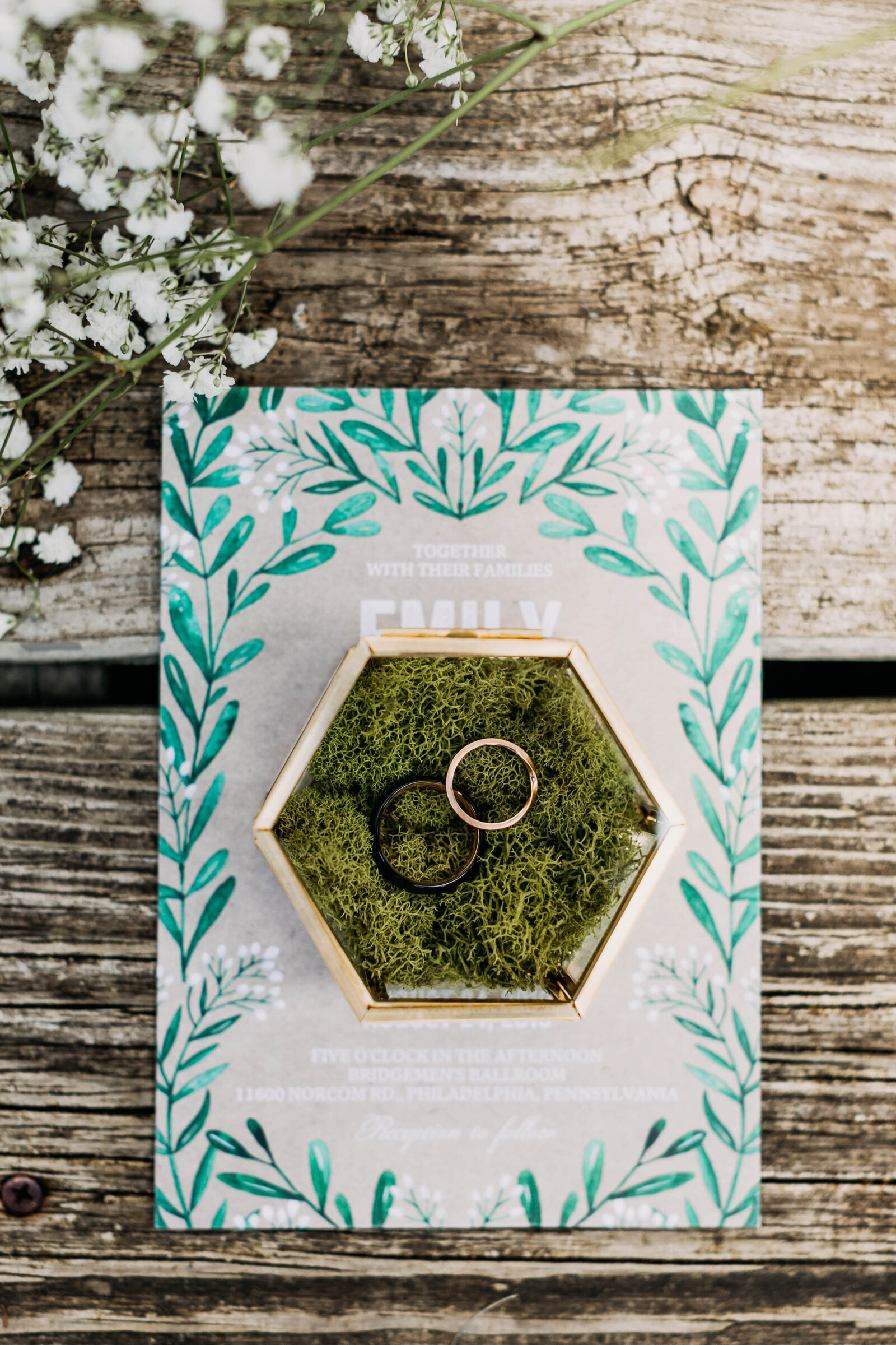 wedding rings in jewelry box with moss