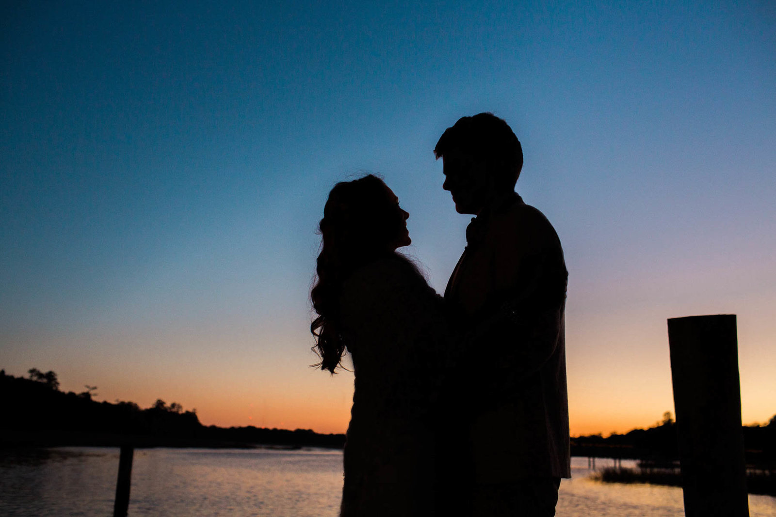 Bride and groom stand on dock at sunset, Boone Hall Plantation, Charleston, South Carolina