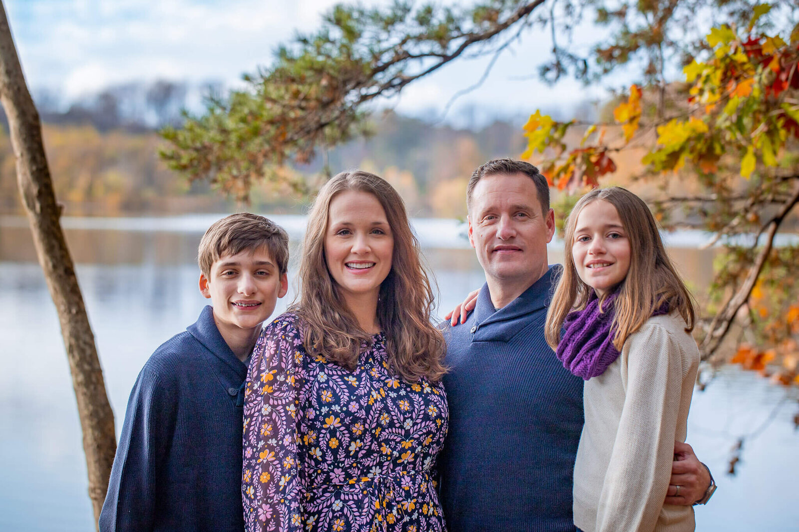 A family of four standing in front of Lake Accotink in Springfield, Virginia.