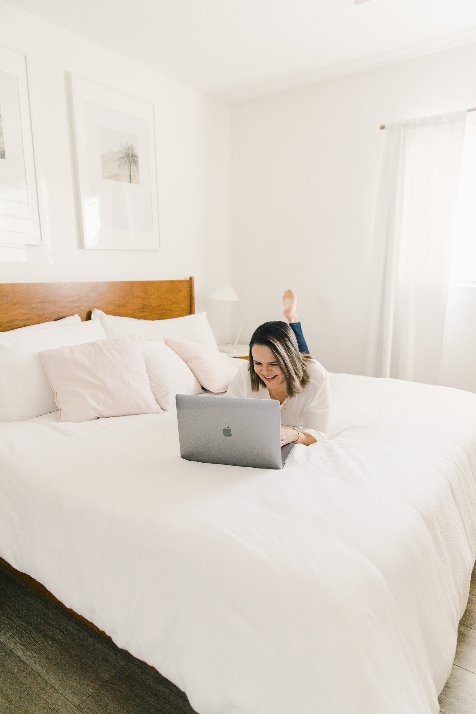 woman laying on a bed with her laptop