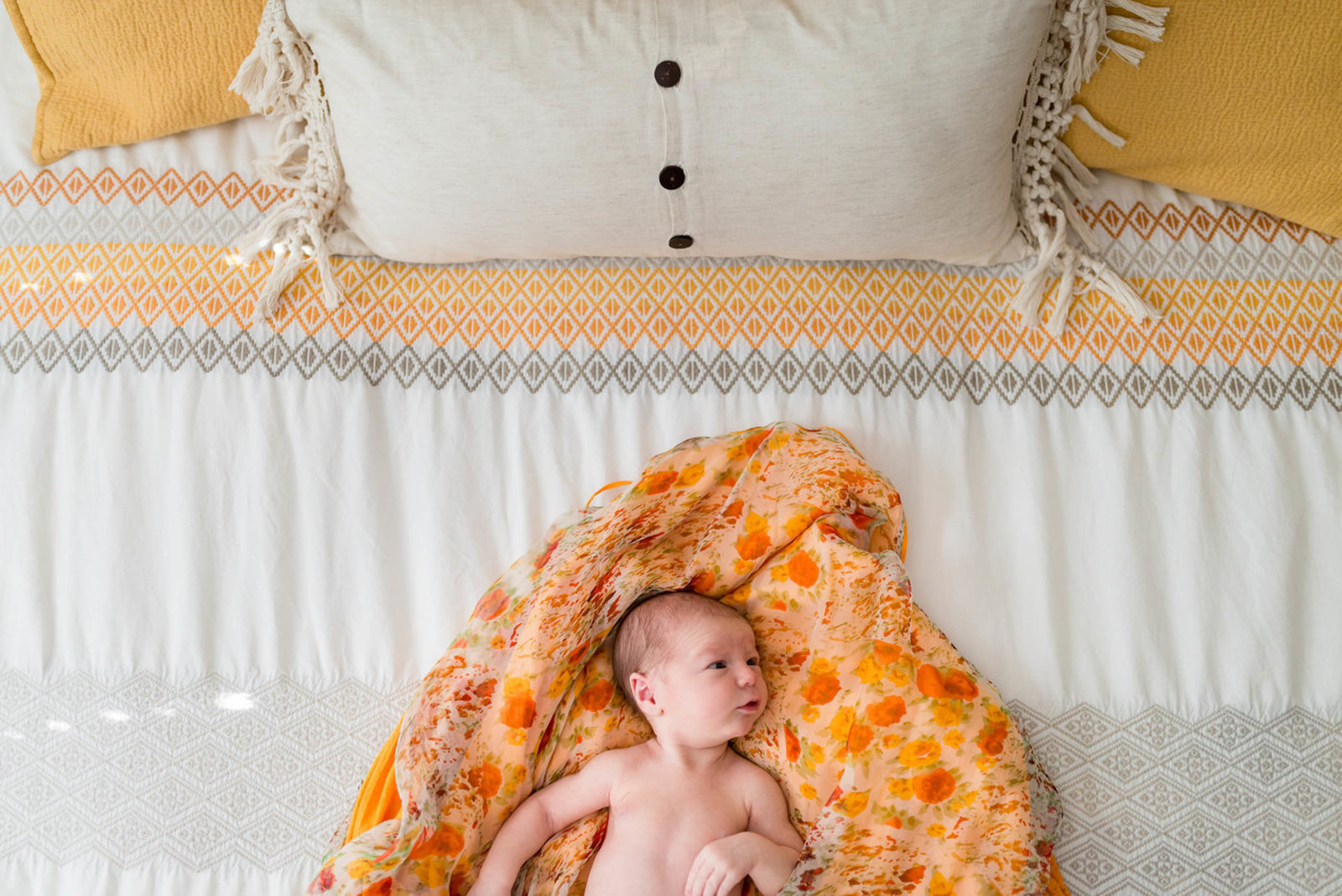 Newborn posed at home on furniture in lifestyle session Boston on bed