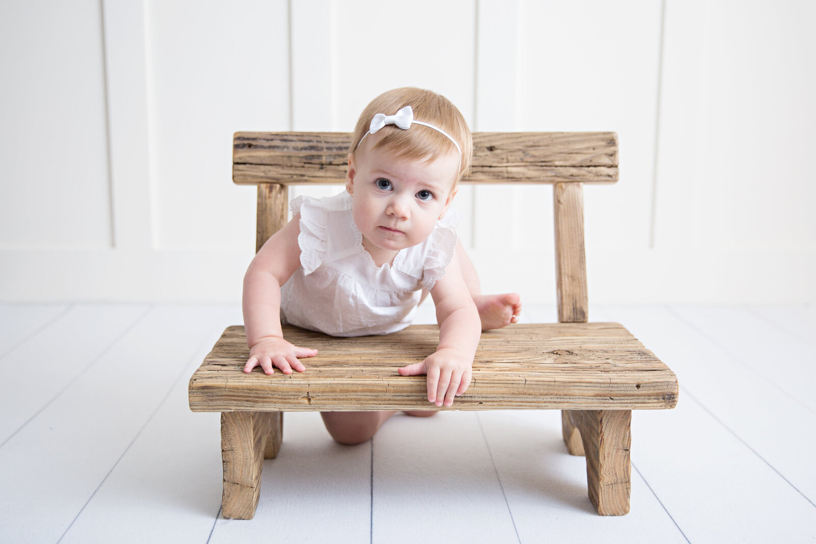 baby girl climbing on tiny bench