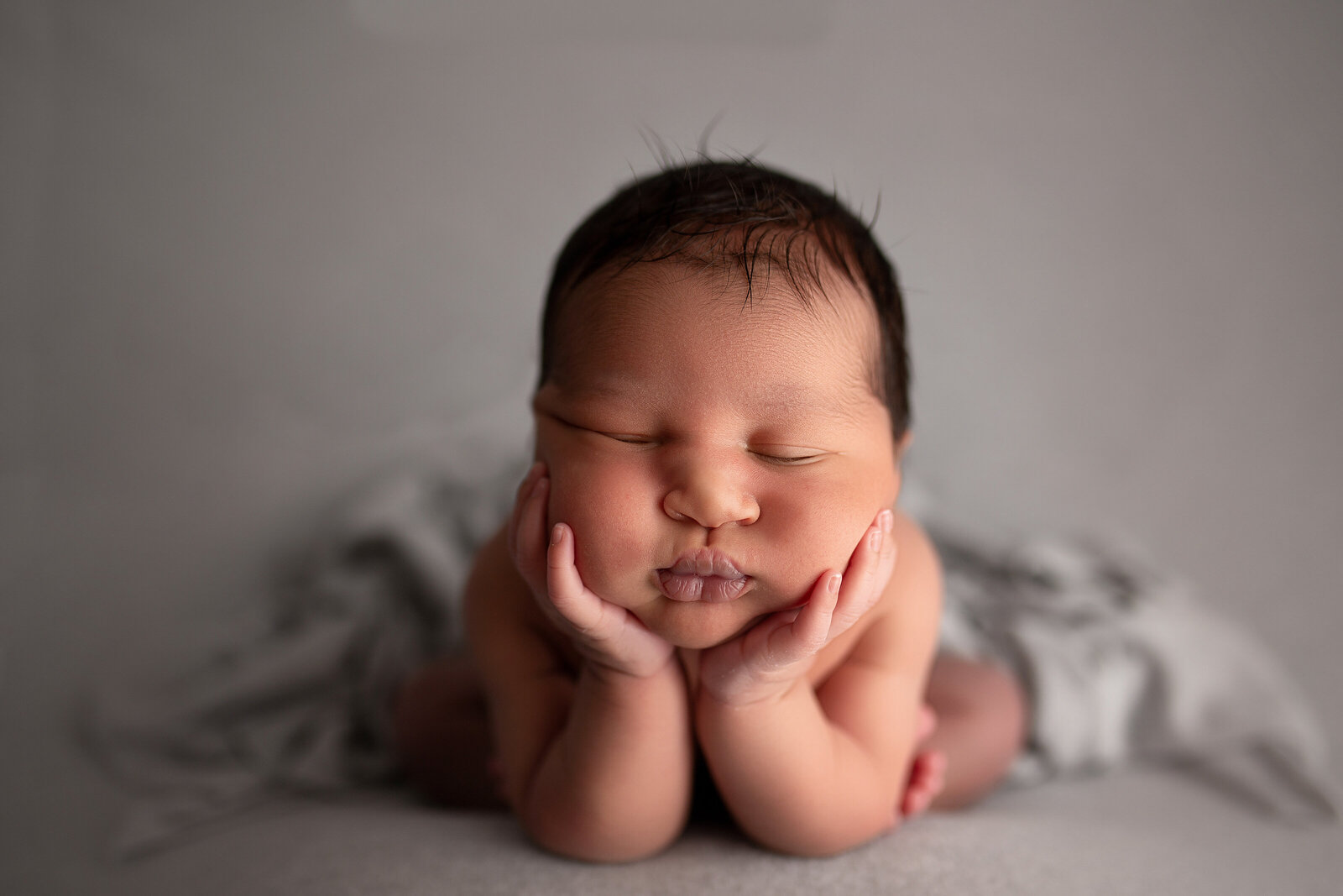 froggy pose baby boy with head in hands newborn