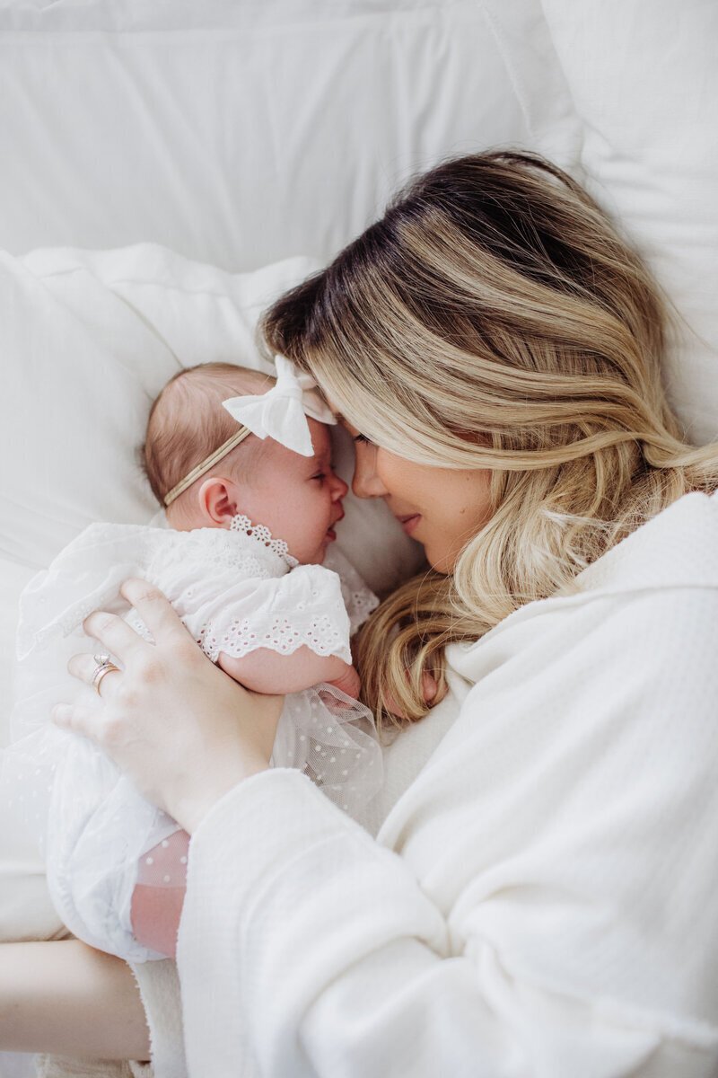 Mom laying on bed with newborn baby