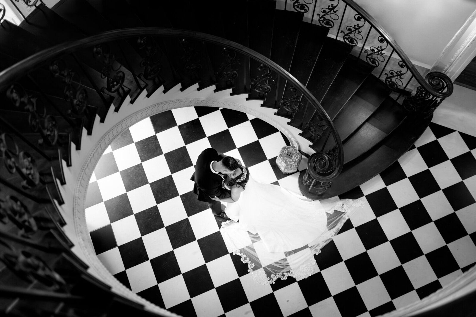 B&W Spiral Staircase Kiss at Swan House in Atlanta Documentary black and white wedding photo of couple kissing on spiral staircase at Swan House in Atlanta