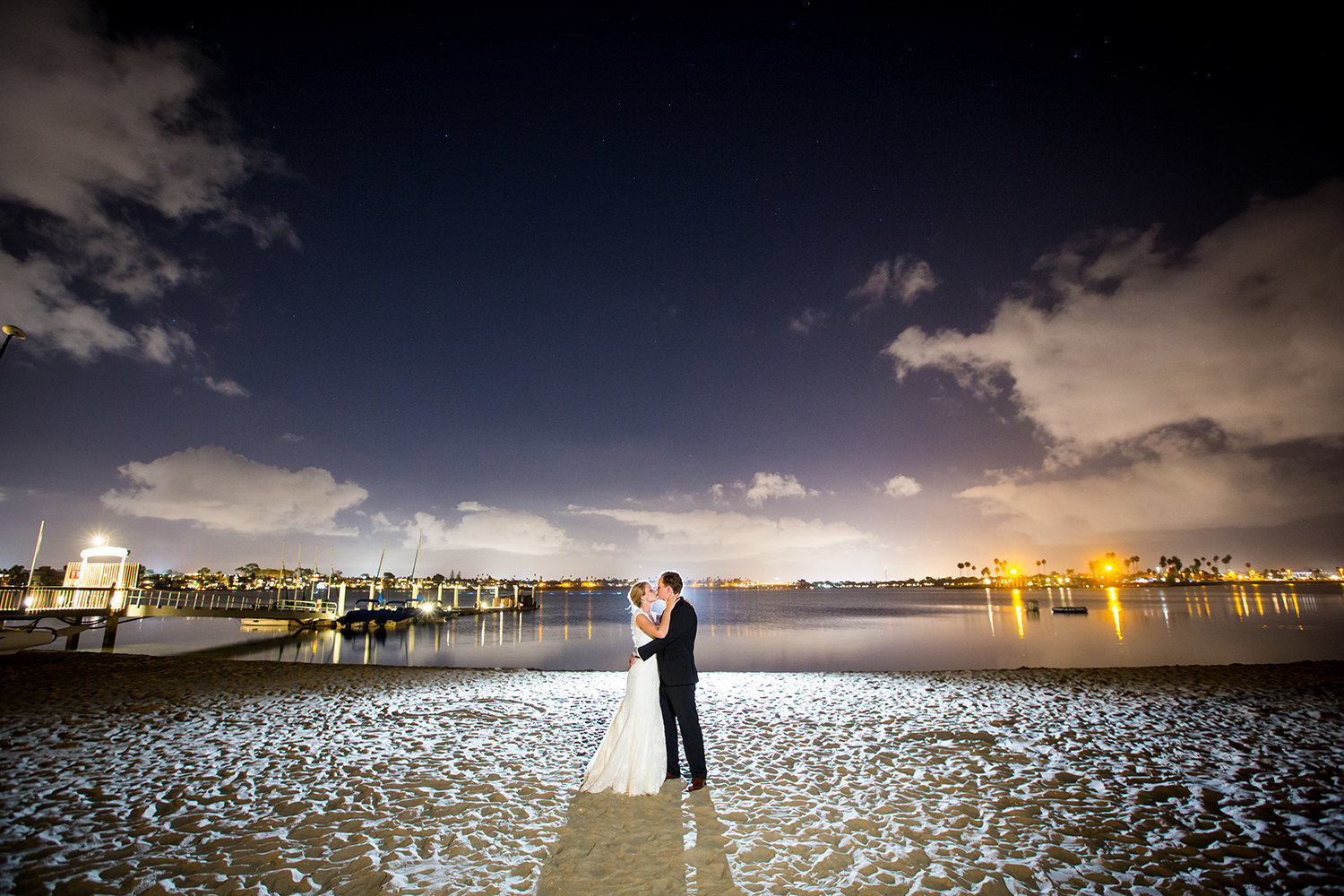 night image of bride and groom and bay in background