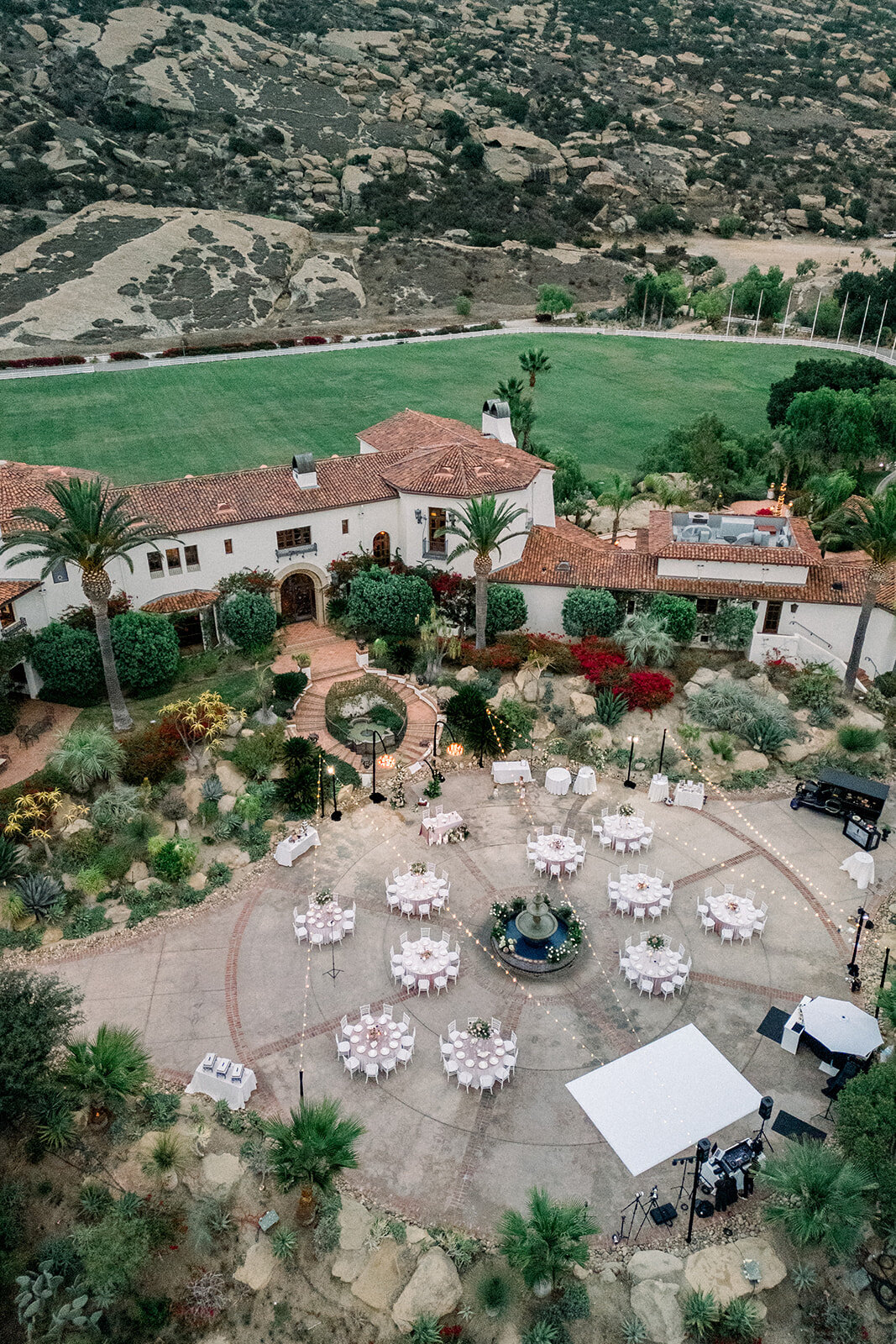 Reception tables styled with white linens and floral centerpieces at Hummingbird Nest Ranch, a luxury Los Angeles wedding venue.