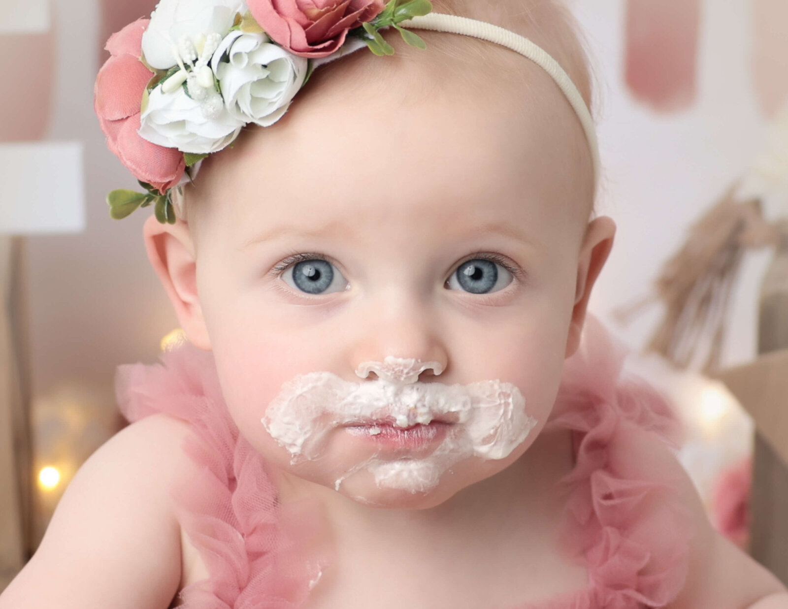 Close up of little girl with cake on her face.