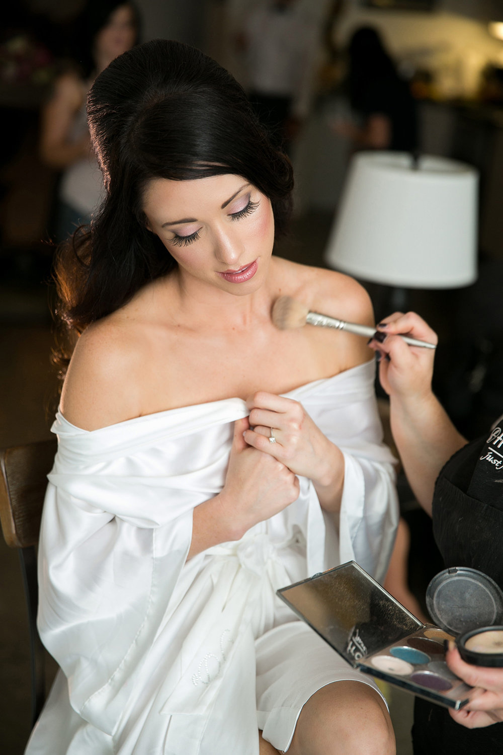 A bride having her makeup done before her wedding