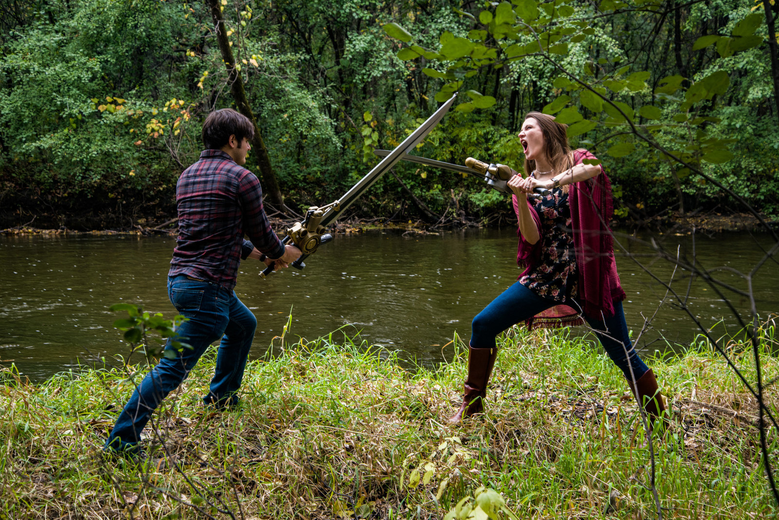 Man and woman sword fighting on riverbank
