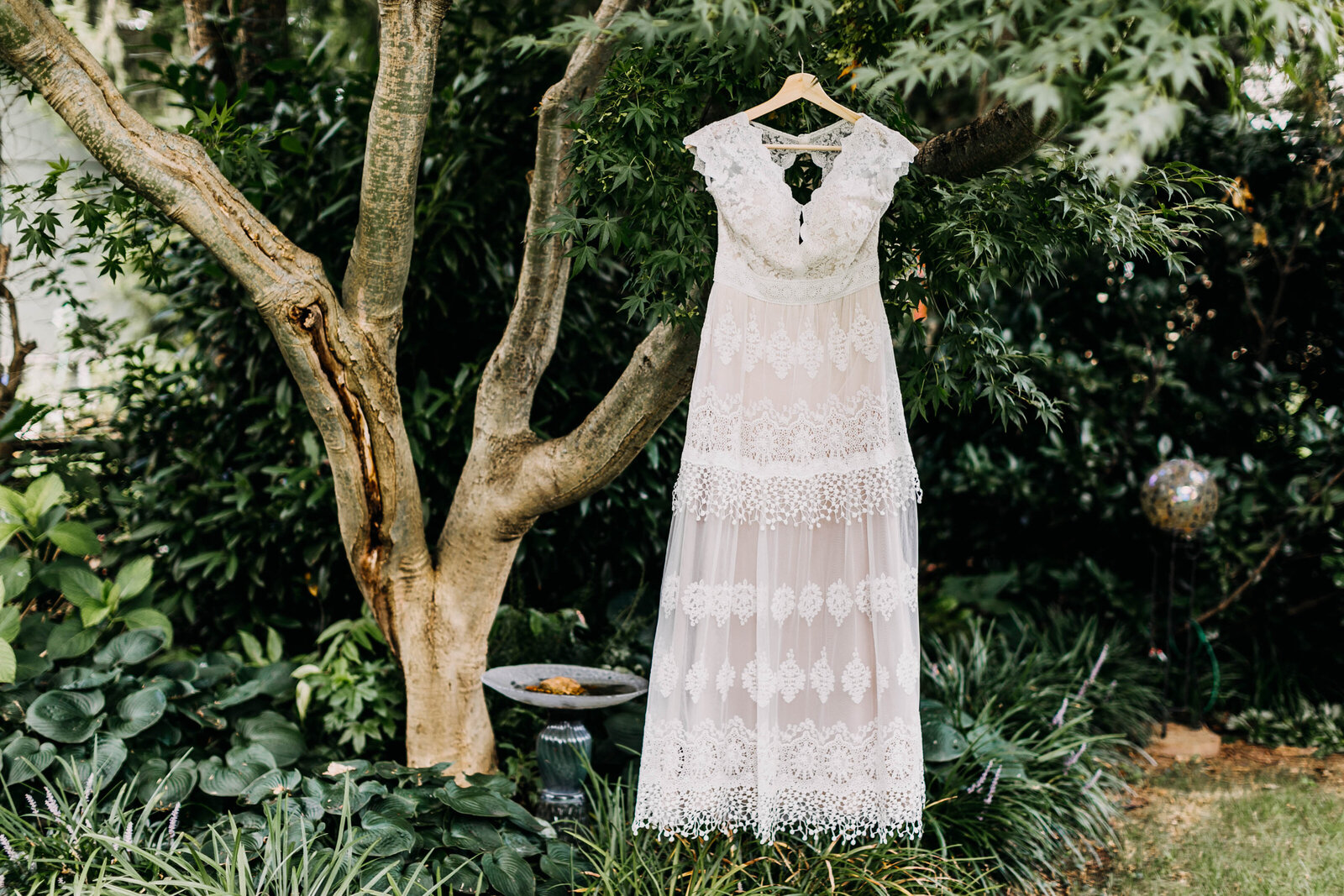 lace wedding dress hanging in tree