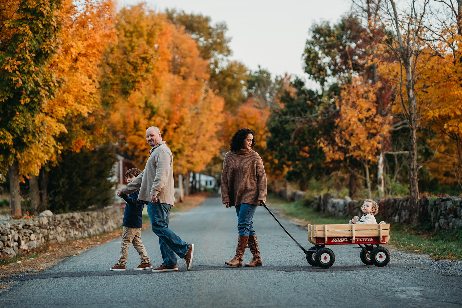 autumn family session where toddler is pulled in a wagon