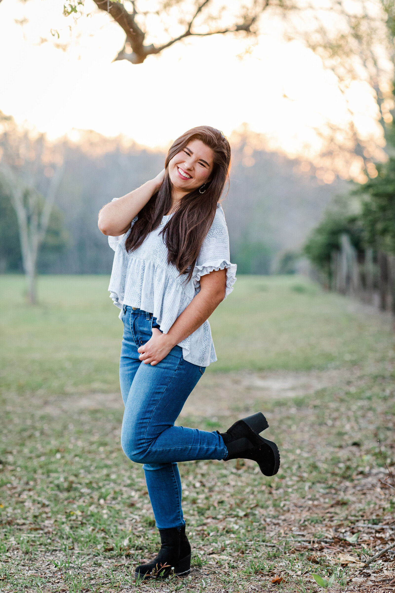 Senior girl photos posing in field with Jennifer Beal Photography