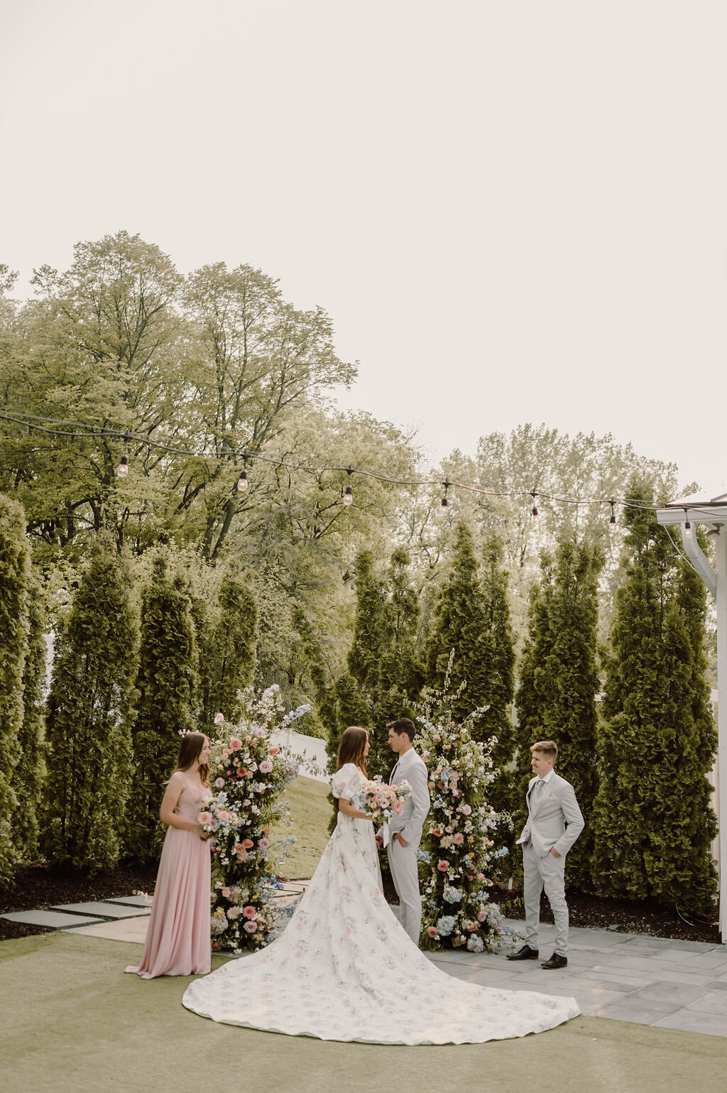 Intimate garden wedding ceremony surrounded by lush florals and greenery