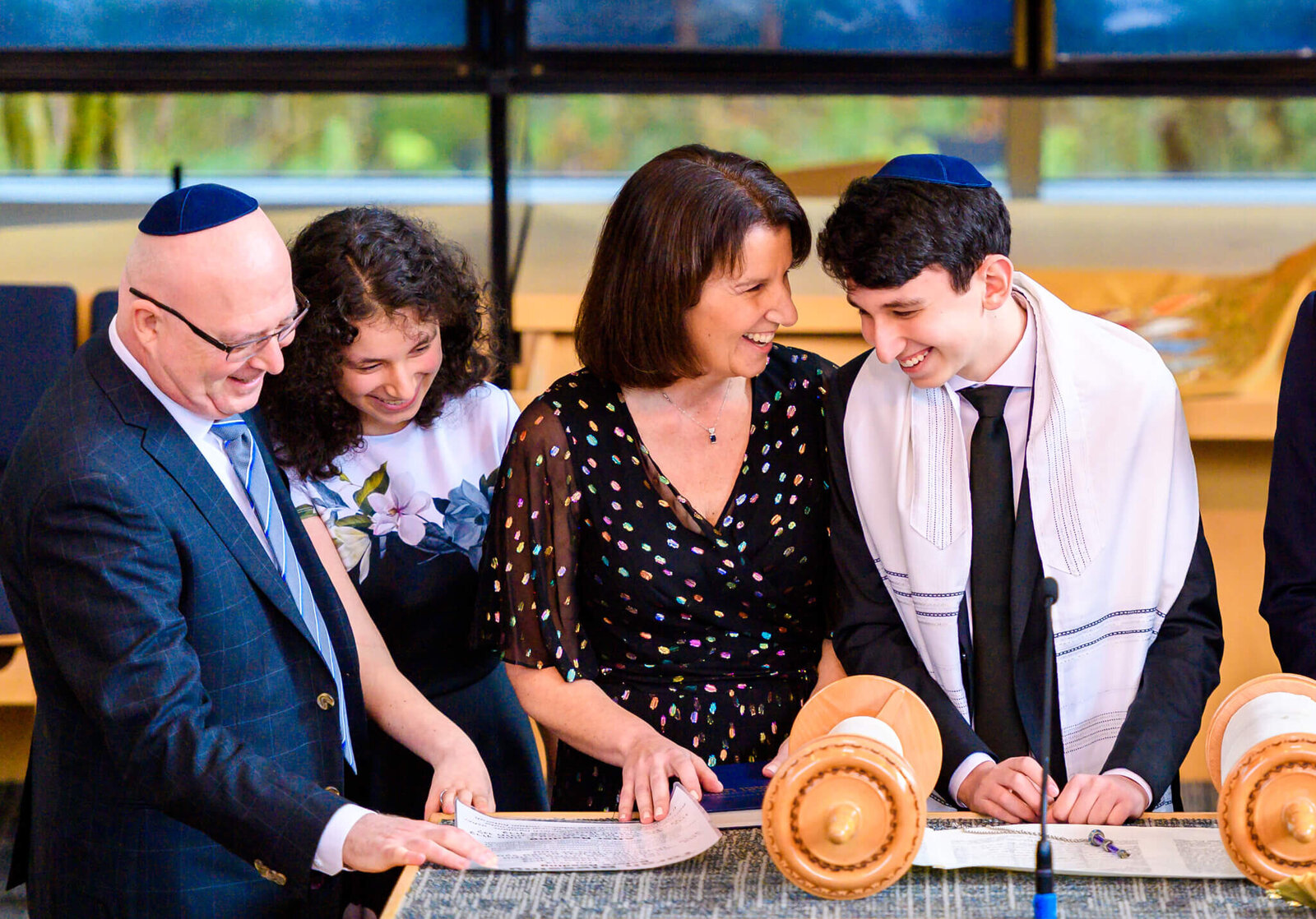 A mom and dad and sister laugh with their son at the Bimah during his Mitzvah