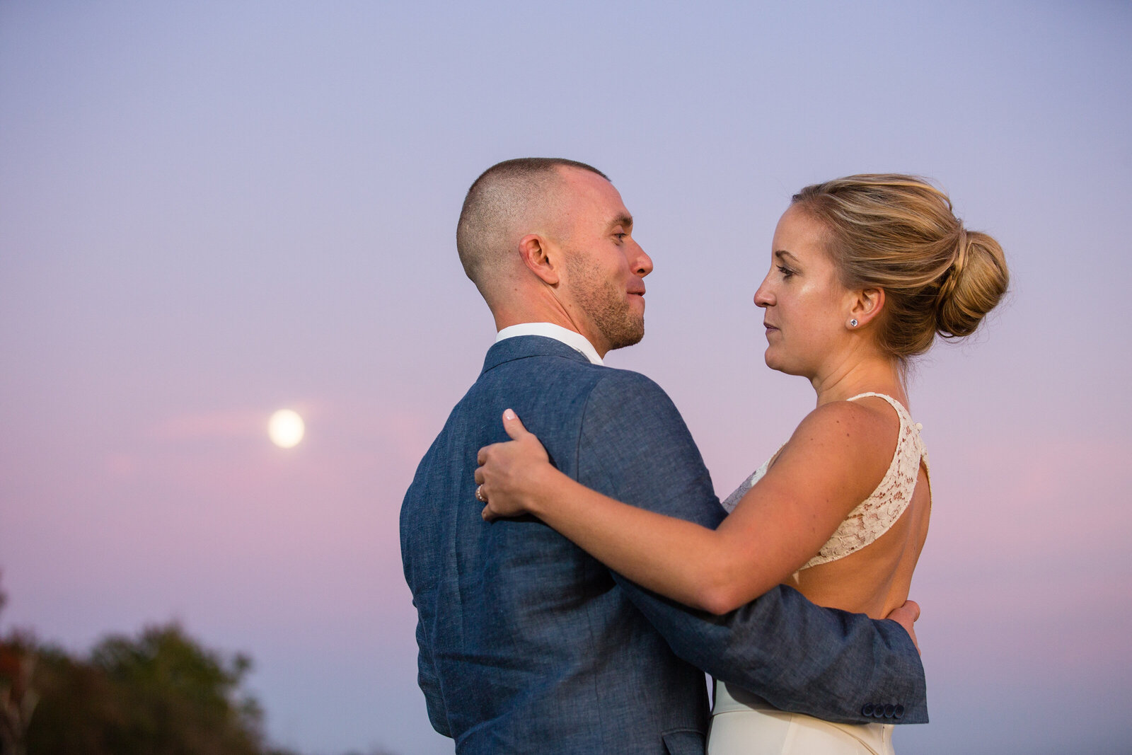couple dances at twilight with moon