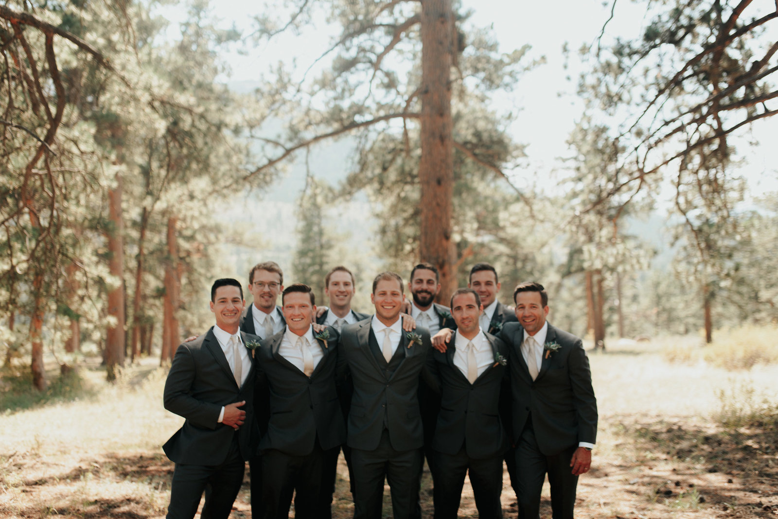 groomsmen gathered for a photo in the woods of red feather lakes colorado.