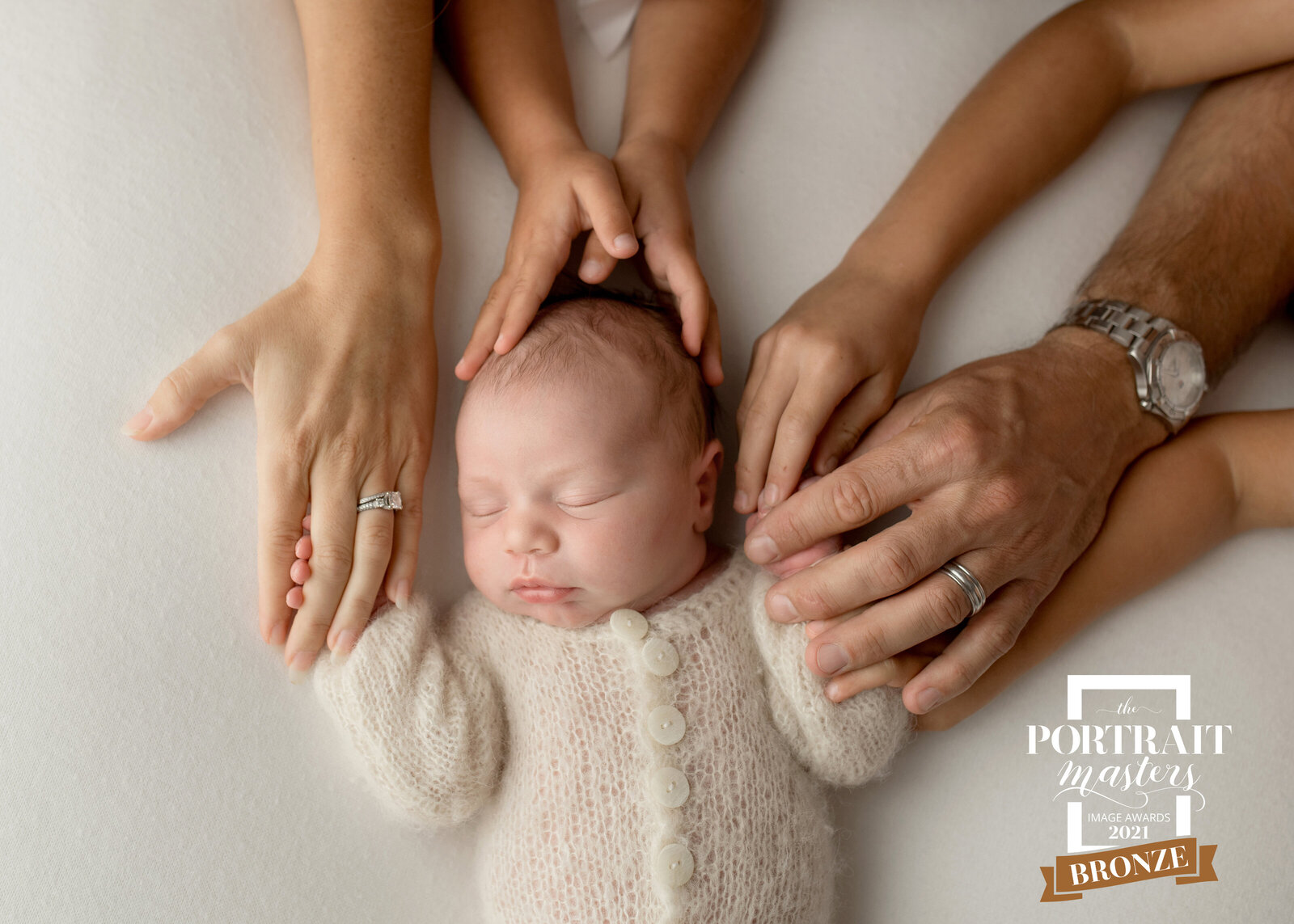 family newborn portrait with newborn baby and parent and sibling hands