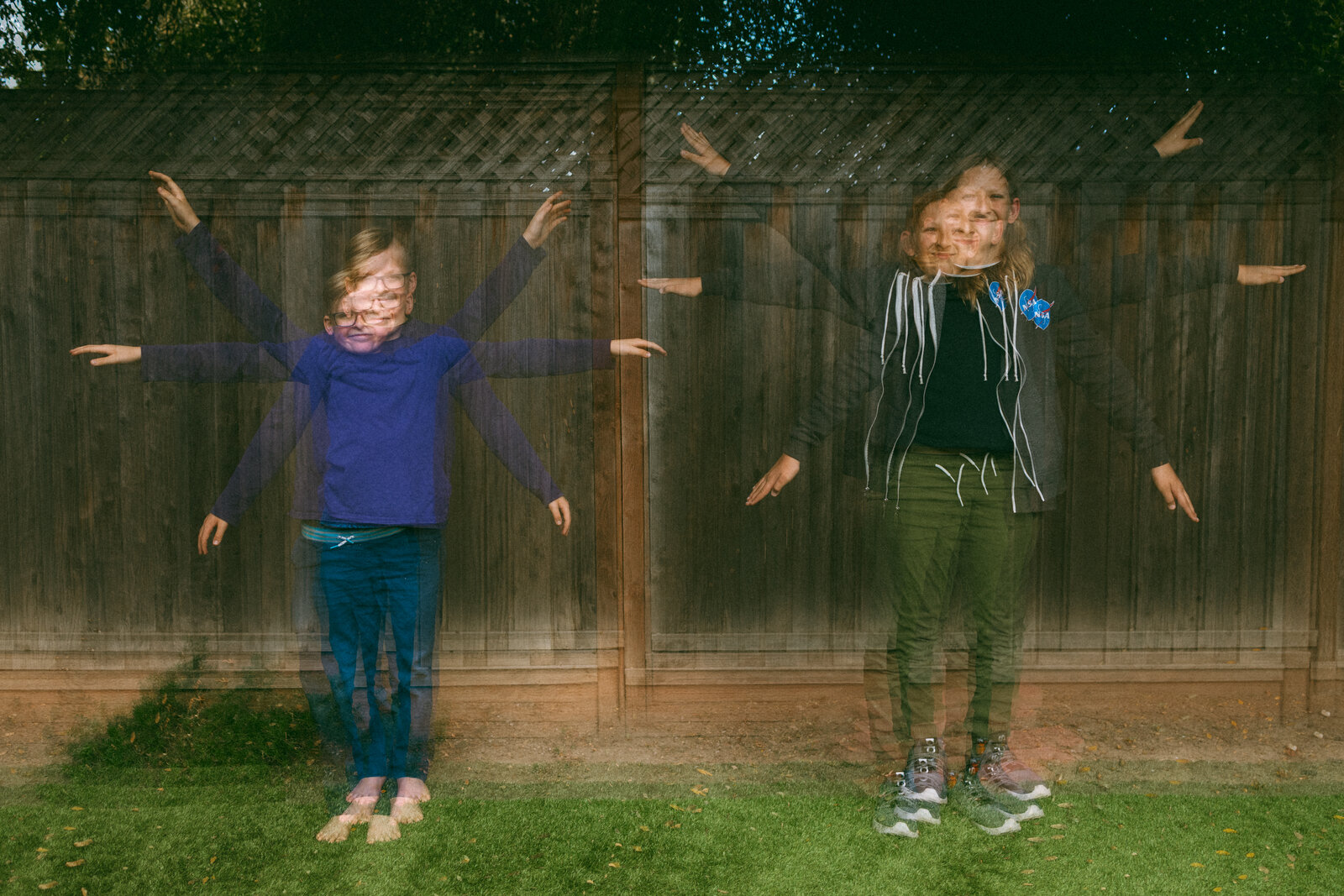 multiple exposure image of two pre teen boys against wooden fence