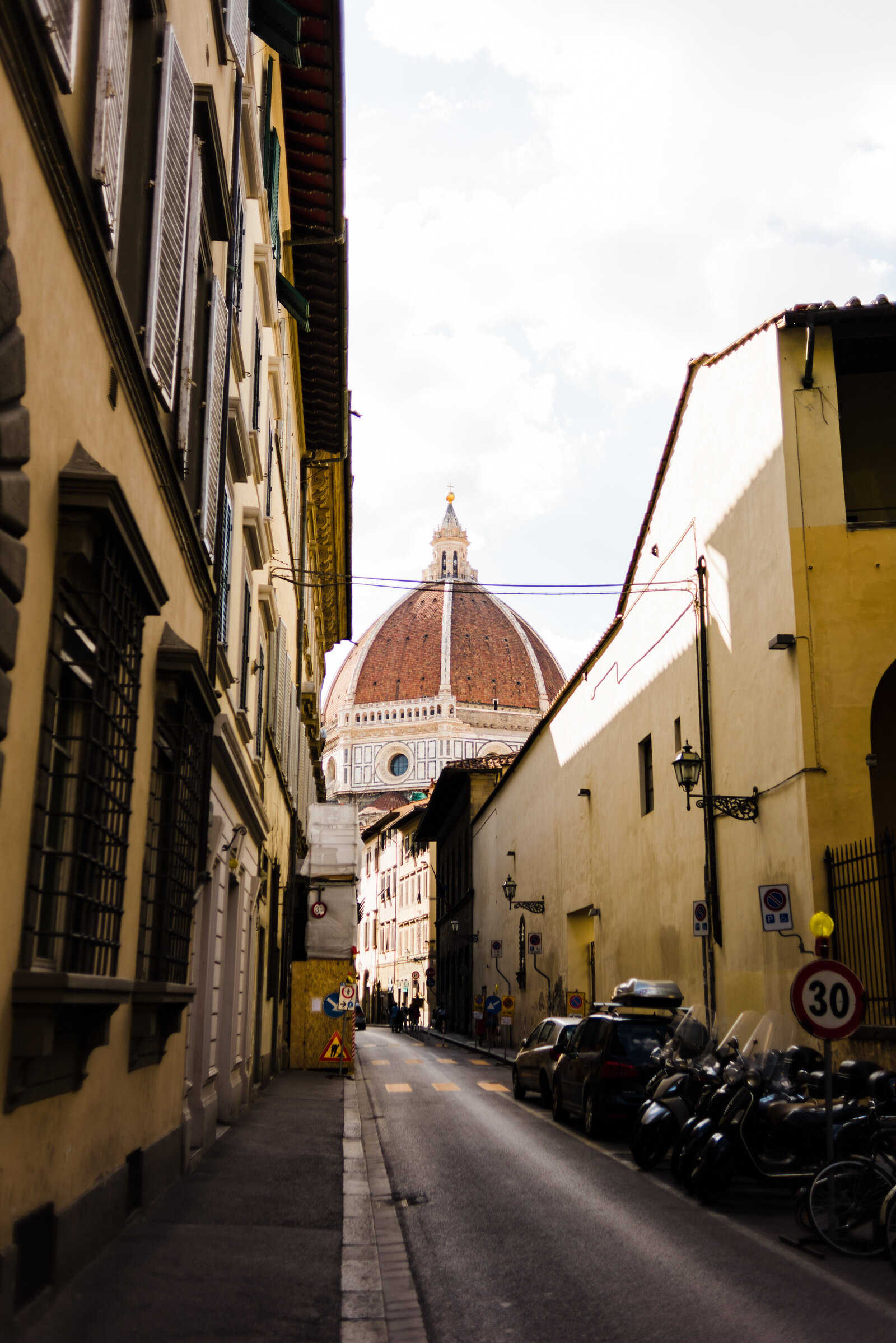 Street in Florence with mopeds and the dome