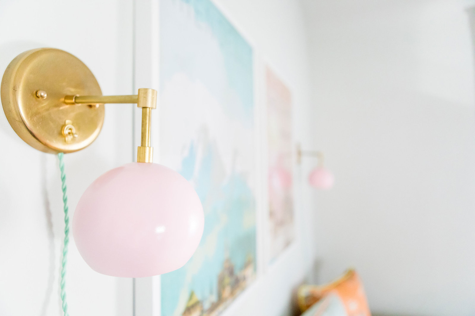Gold and pink globe sconces in a nursery.