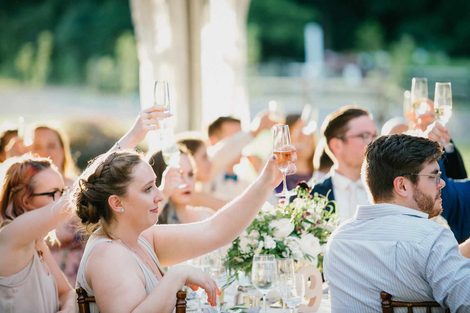 Guests raise up their glasses for a toast to the newly wed couple.
