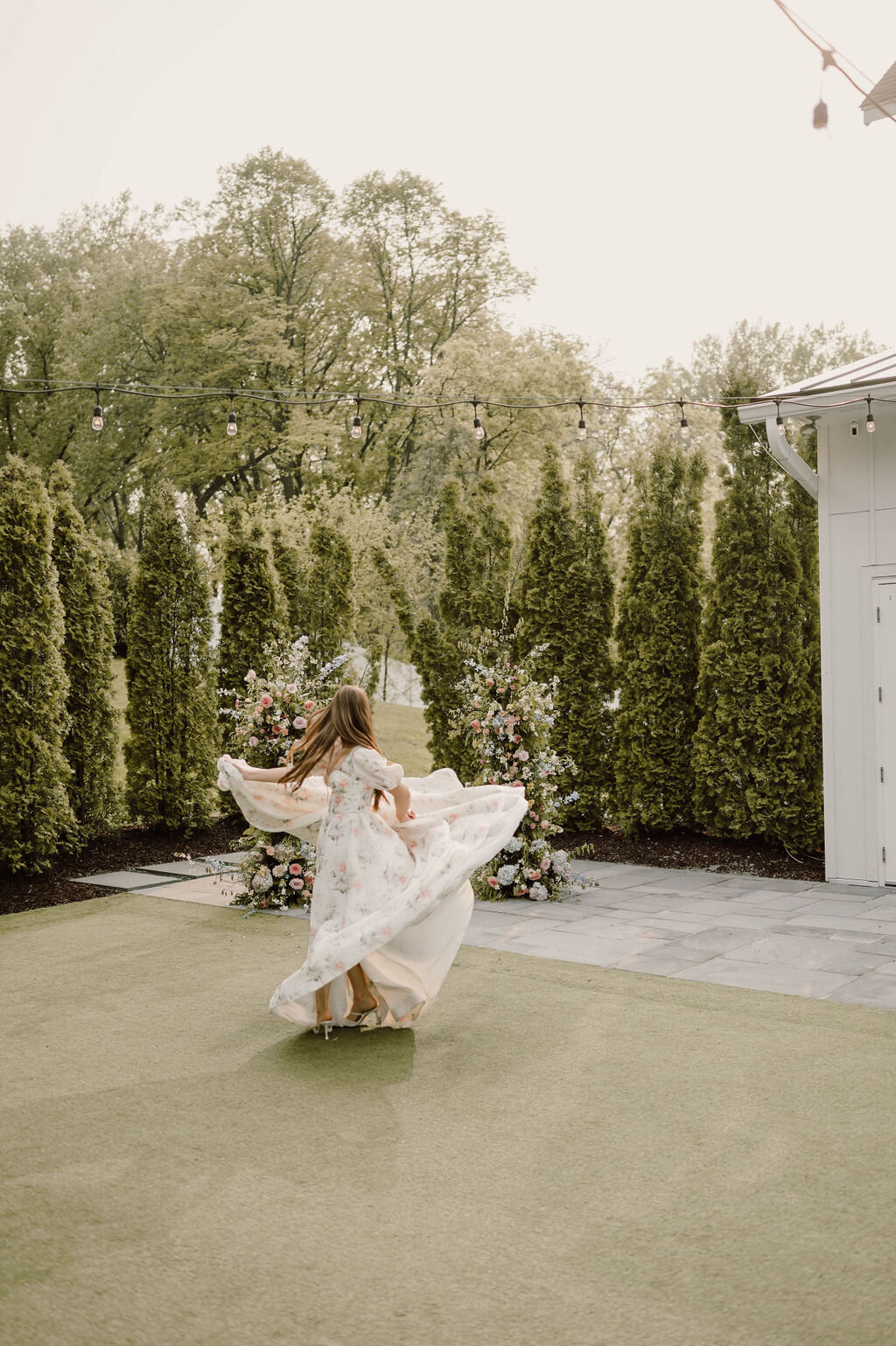 Whimsical bride twirling in floral wedding dress during garden wedding